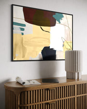 Abstract painting on a wall above a wooden console table with decorative items.