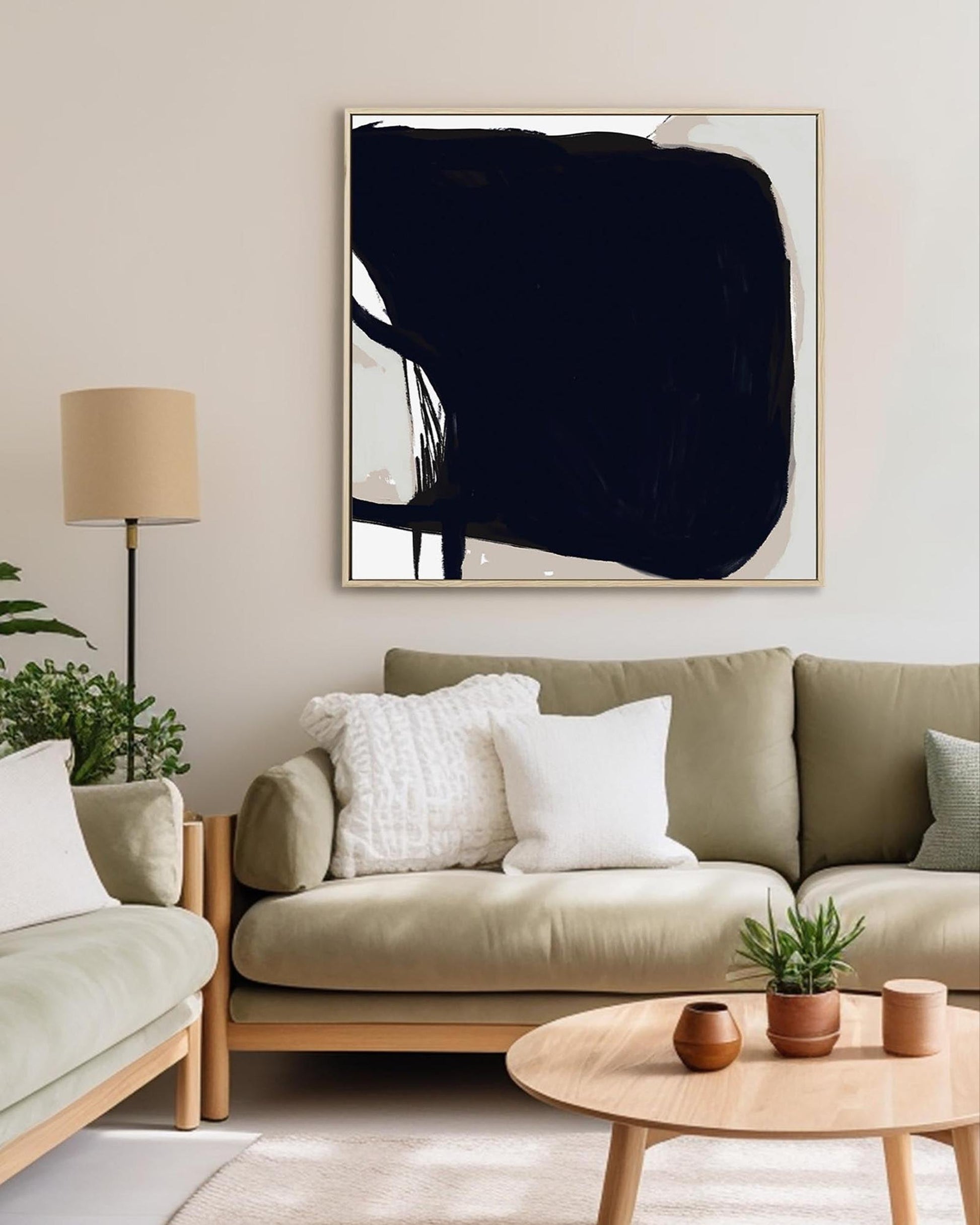 Modern living room with a beige sofa, abstract art, and decorative items.