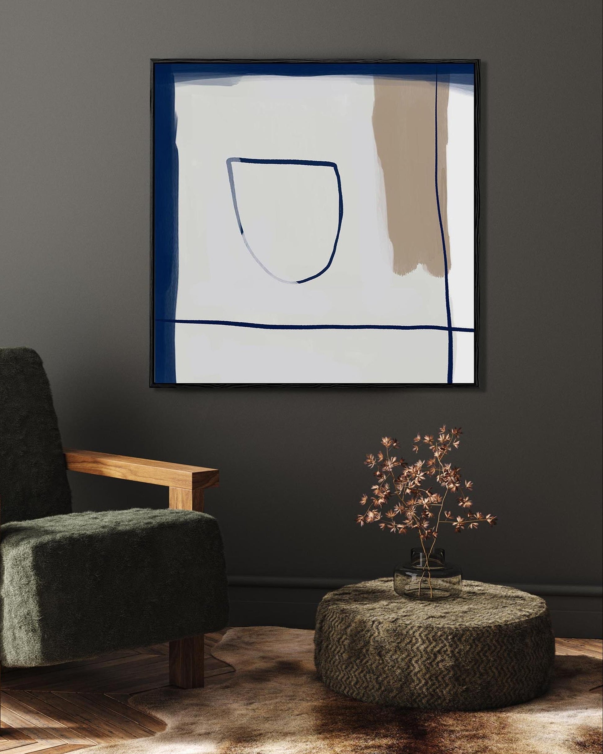 Modern living room with a green armchair, abstract art on the wall, and a textured ottoman.