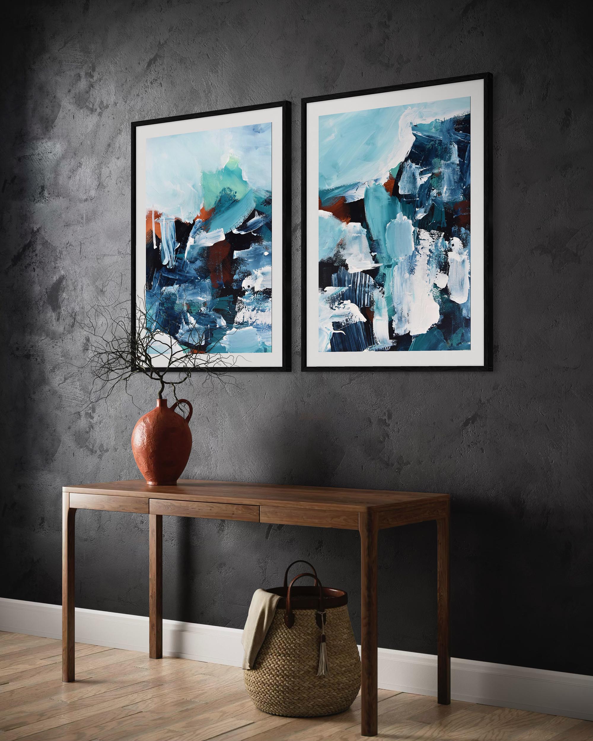 Two abstract paintings on a dark wall above a wooden console table.