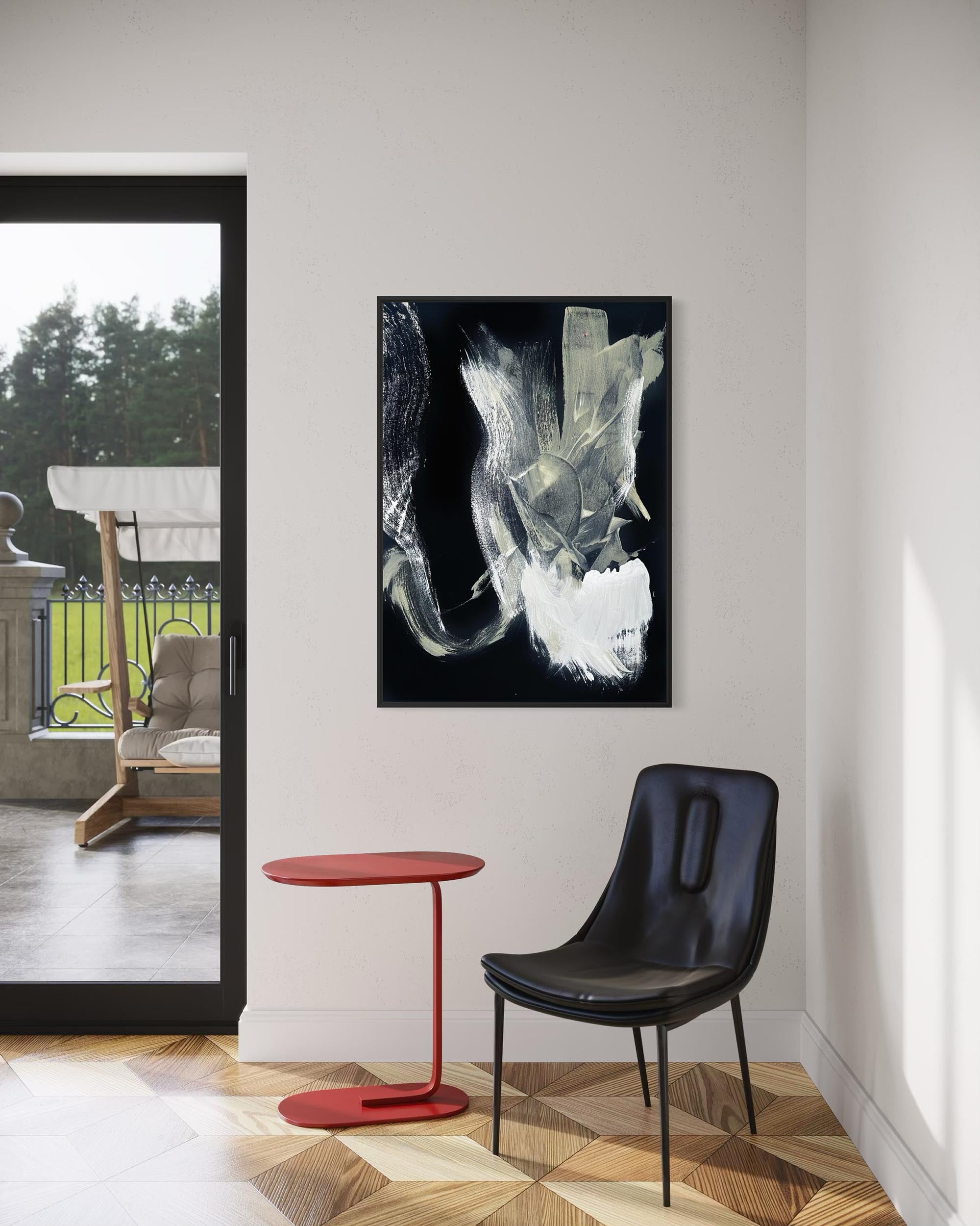 Modern interior with abstract art, red side table, and black chair.
