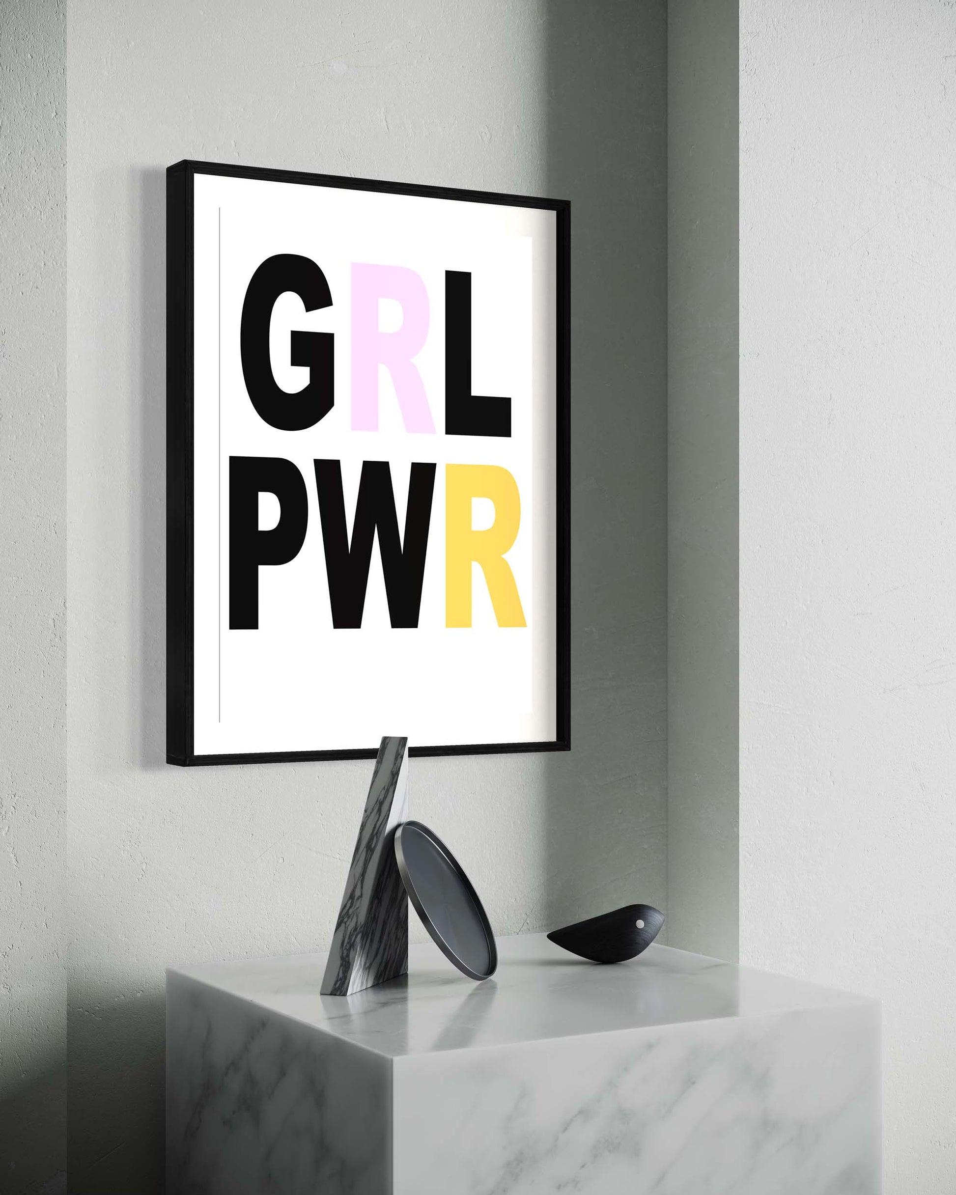 Framed poster with 'GRL PWR' text on a gray wall