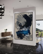 Abstract painting in a modern interior setting with a view of a garden.
