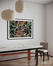Abstract artwork on a wall above a dining table with a chair.