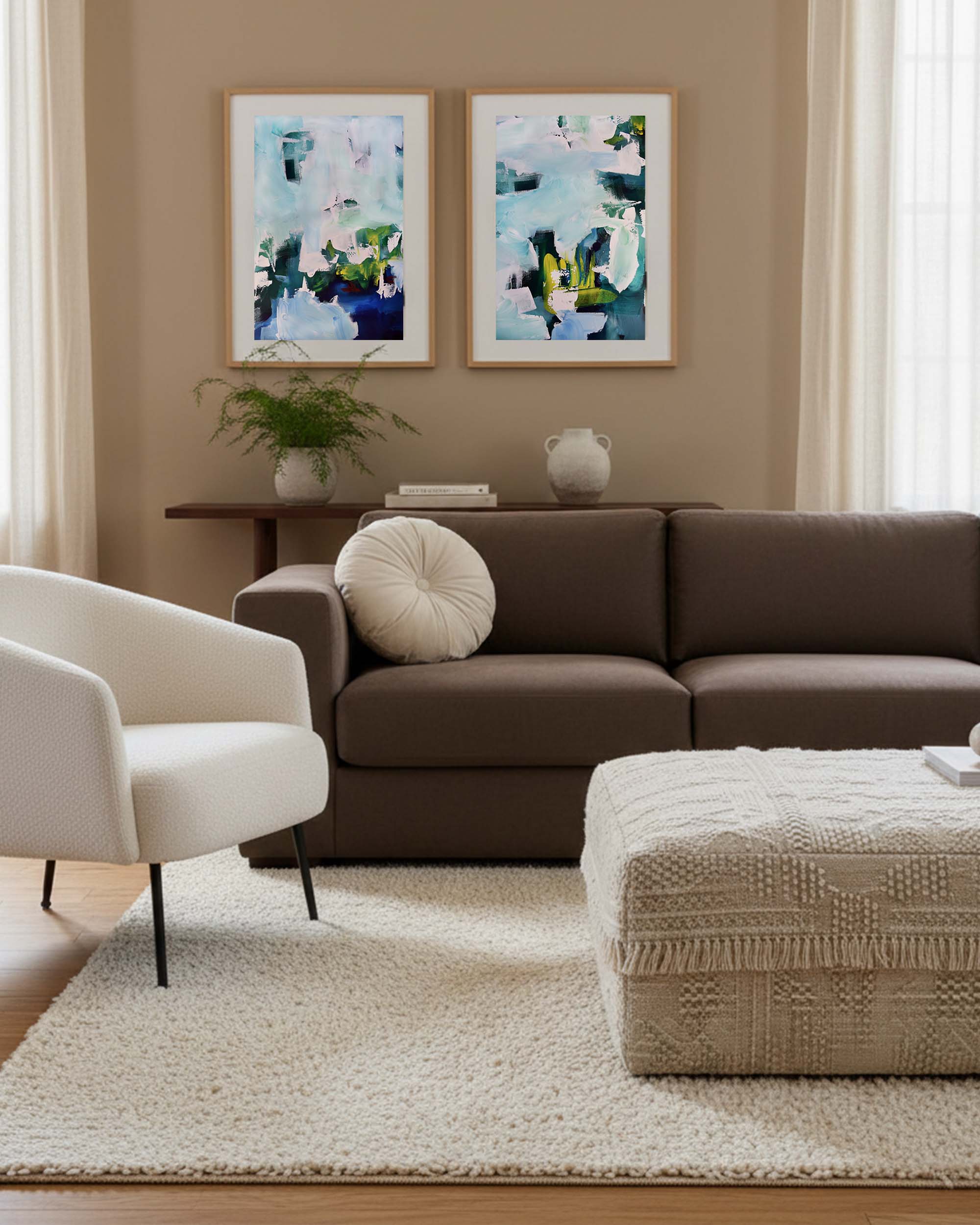 Living room with brown sofa, white armchair, and abstract art on beige walls.