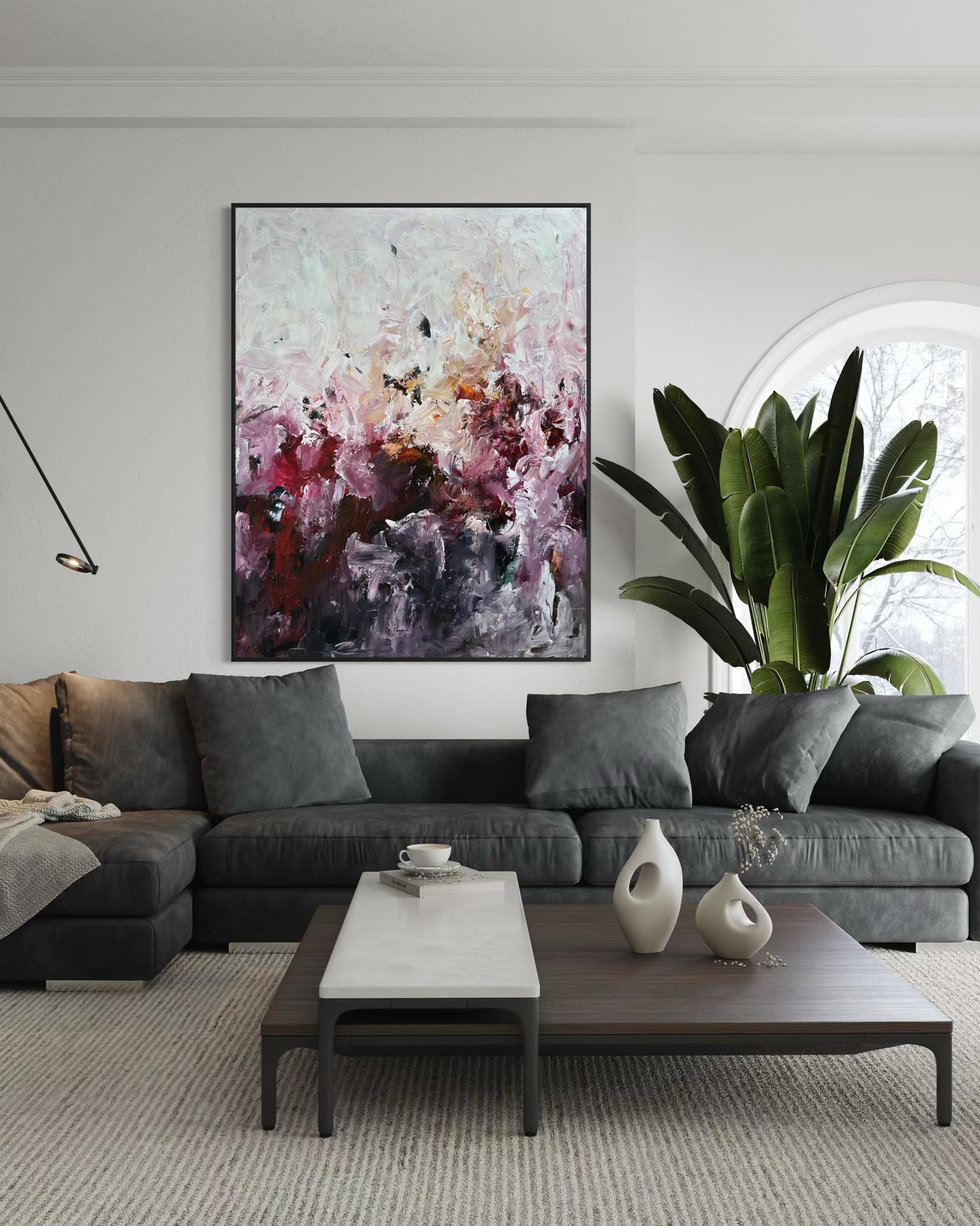 Modern living room with a gray sectional sofa, coffee table, and abstract painting on the wall.