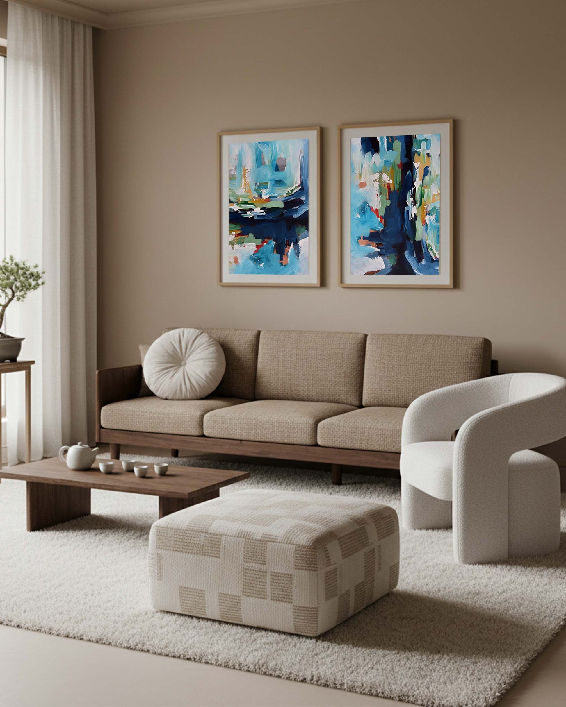 Modern living room with a beige sofa, white armchair, and abstract art on the wall.