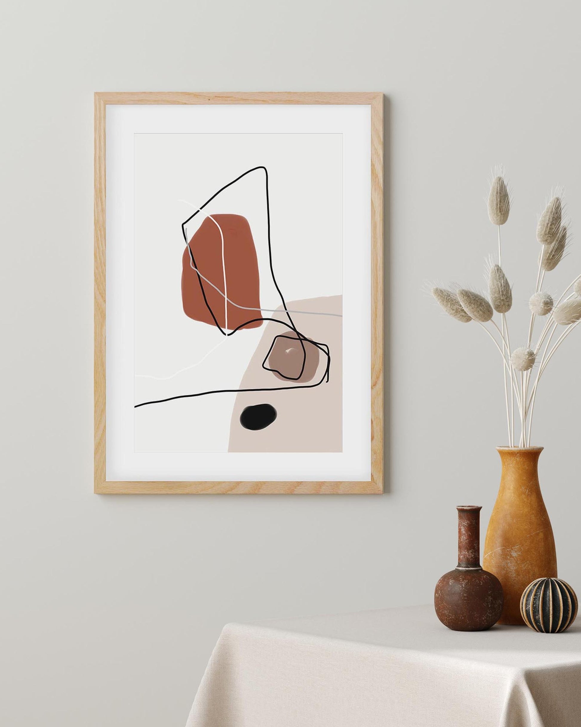 Framed abstract art print on a wall with decorative vases below.