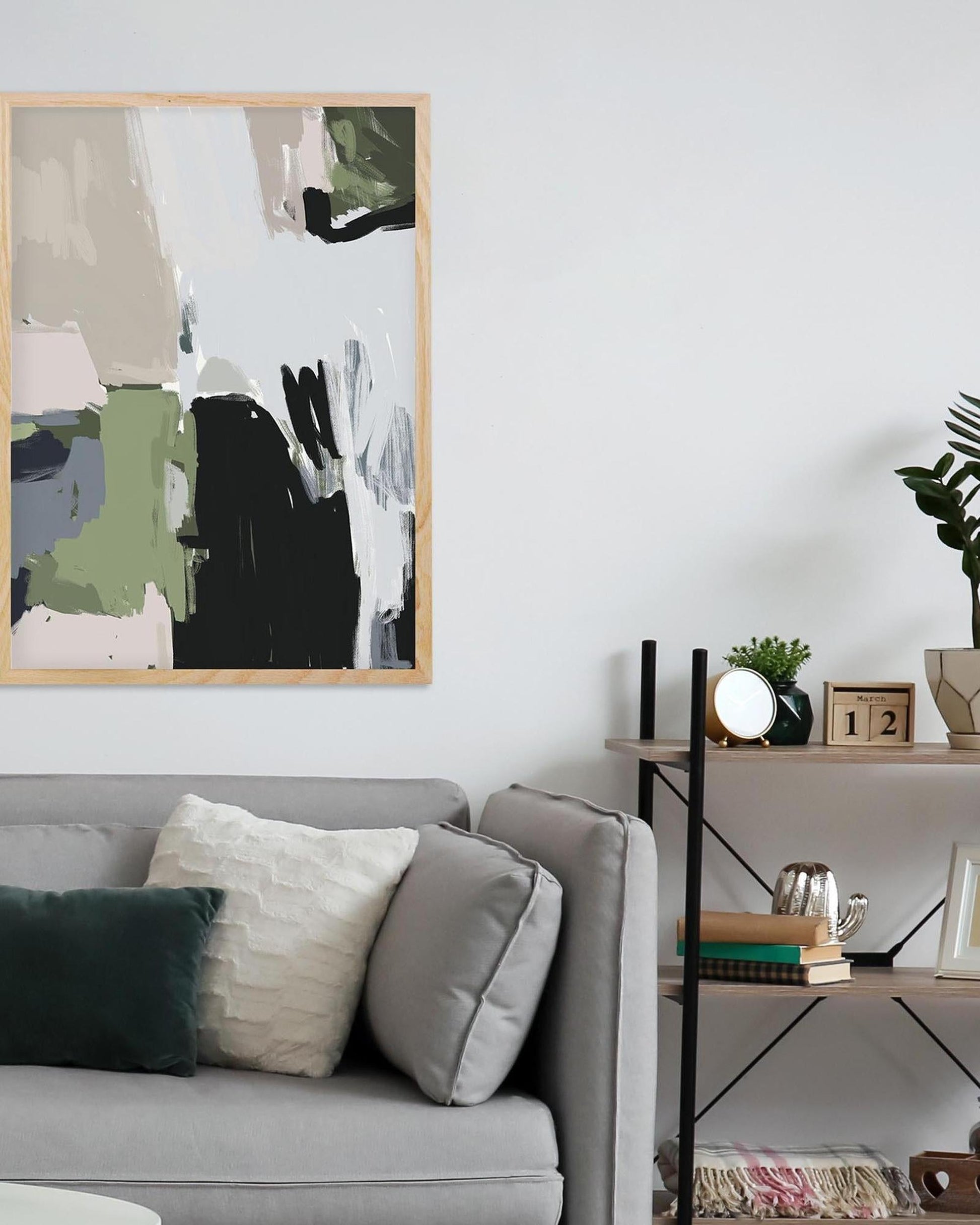 Living room with abstract art on the wall, gray sofa, and decorative items.