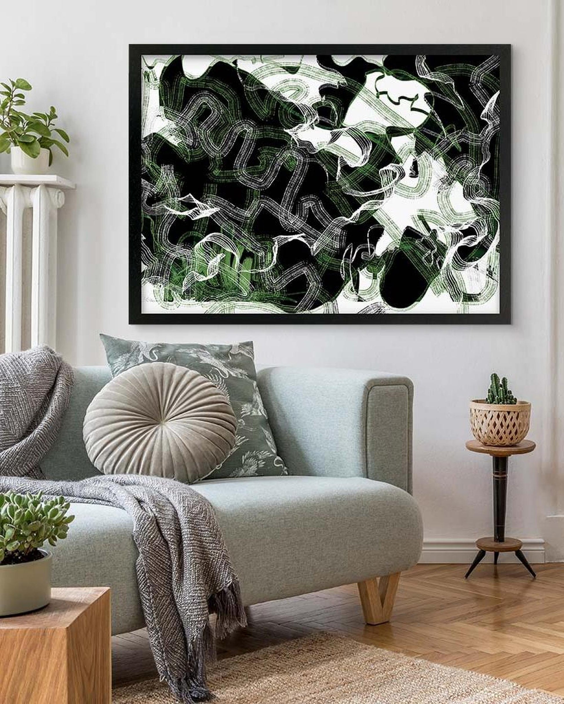 Abstract artwork in a living room with a sofa and decorative items.