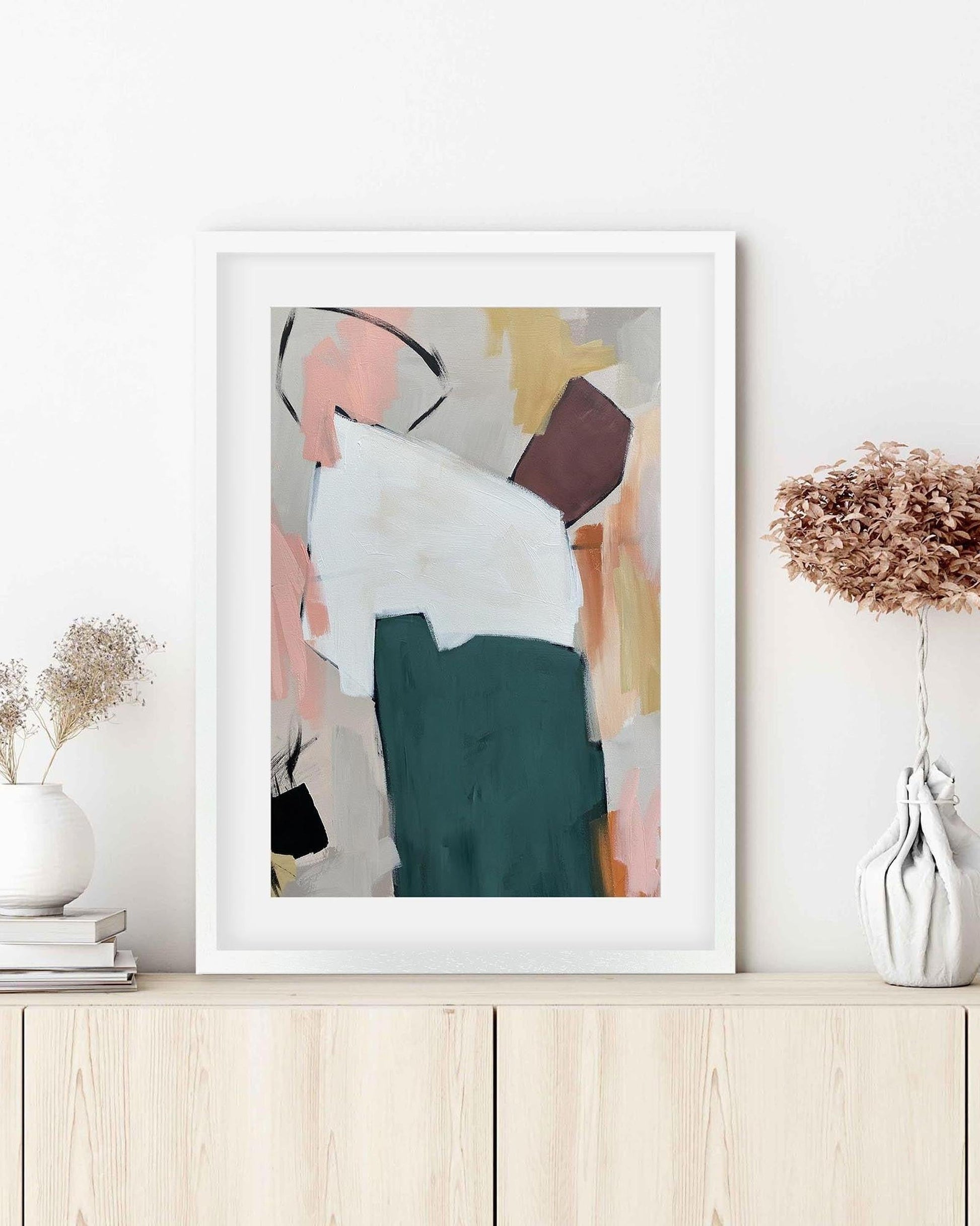 Framed abstract art print on a wall with decorative elements.