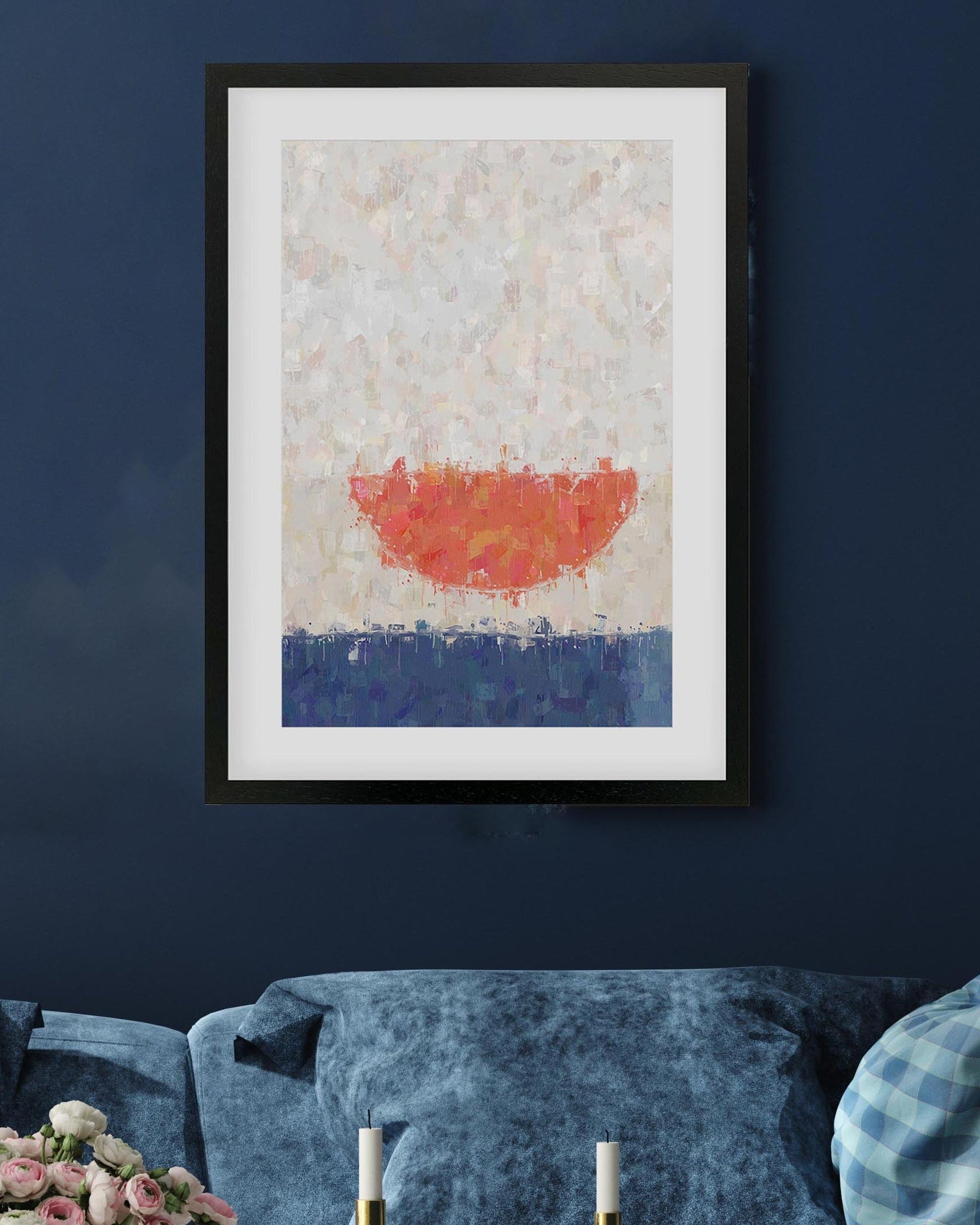 Framed abstract art piece with red and blue colors on a dark blue wall.