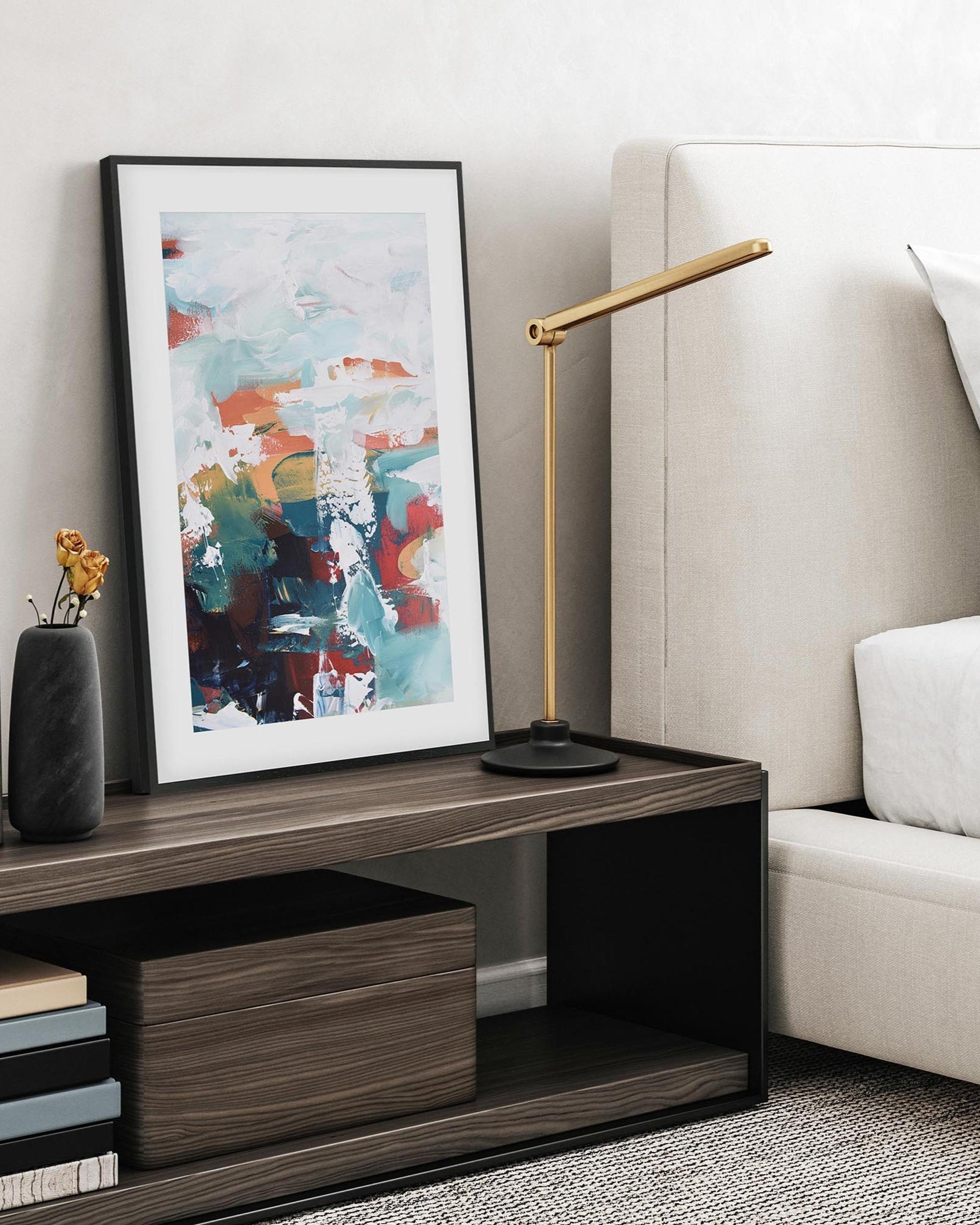 framed art print on a side table in bedroom