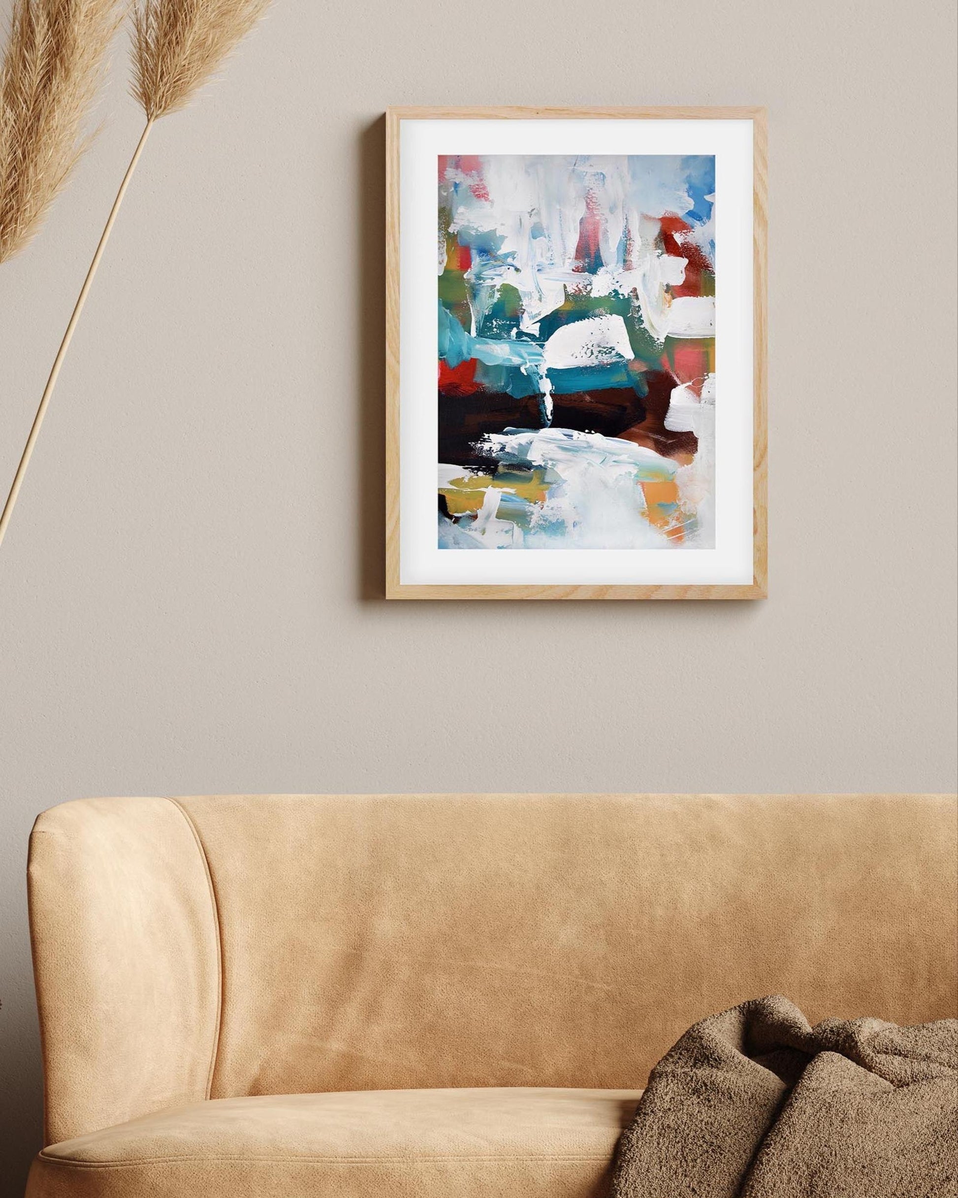 Abstract painting on a wall above a beige sofa with decorative elements.