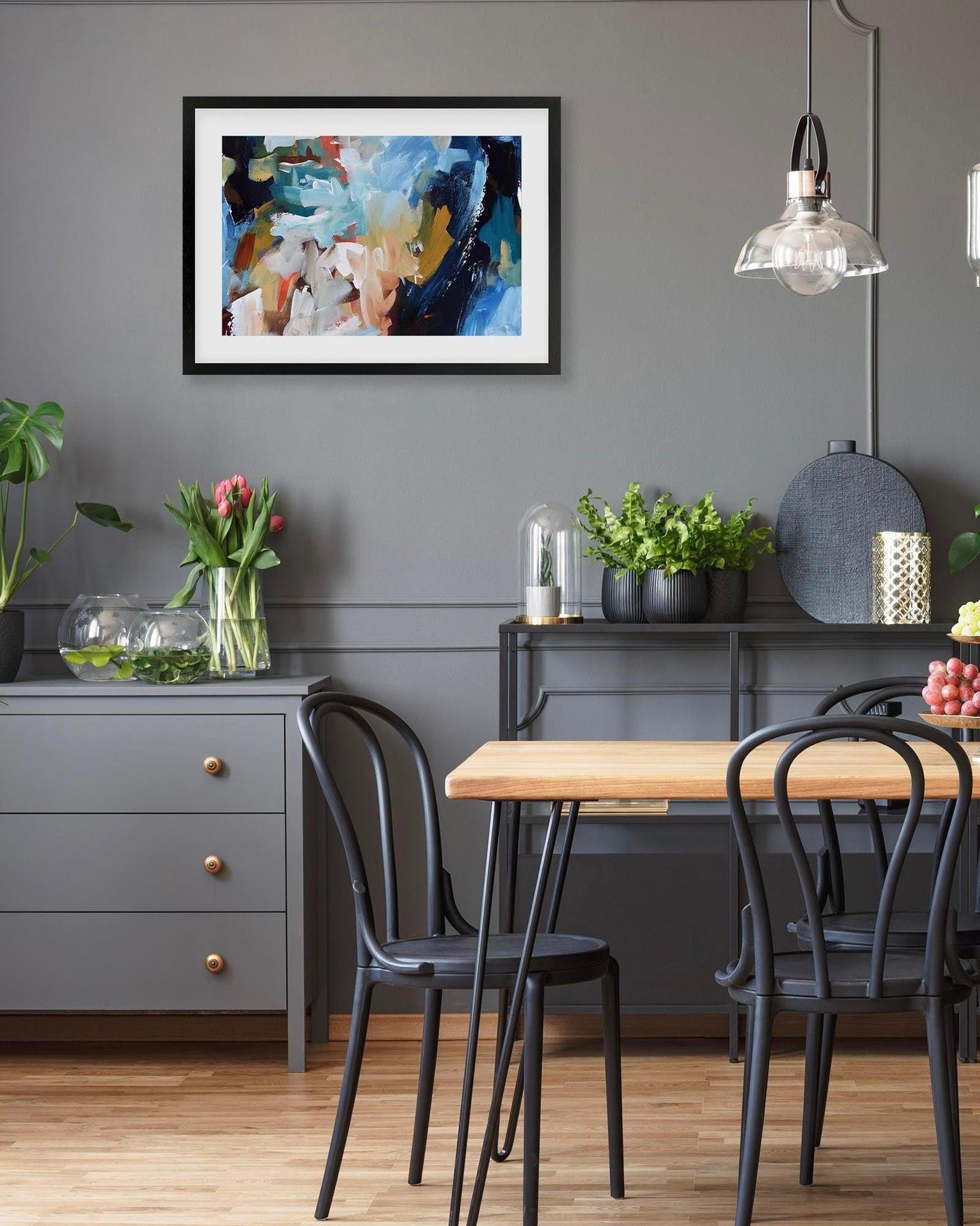 Dining room with a table, chairs, and decorative items against a gray wall.