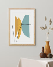 Framed abstract art print with geometric shapes on a wall above a table with decorative vases.
