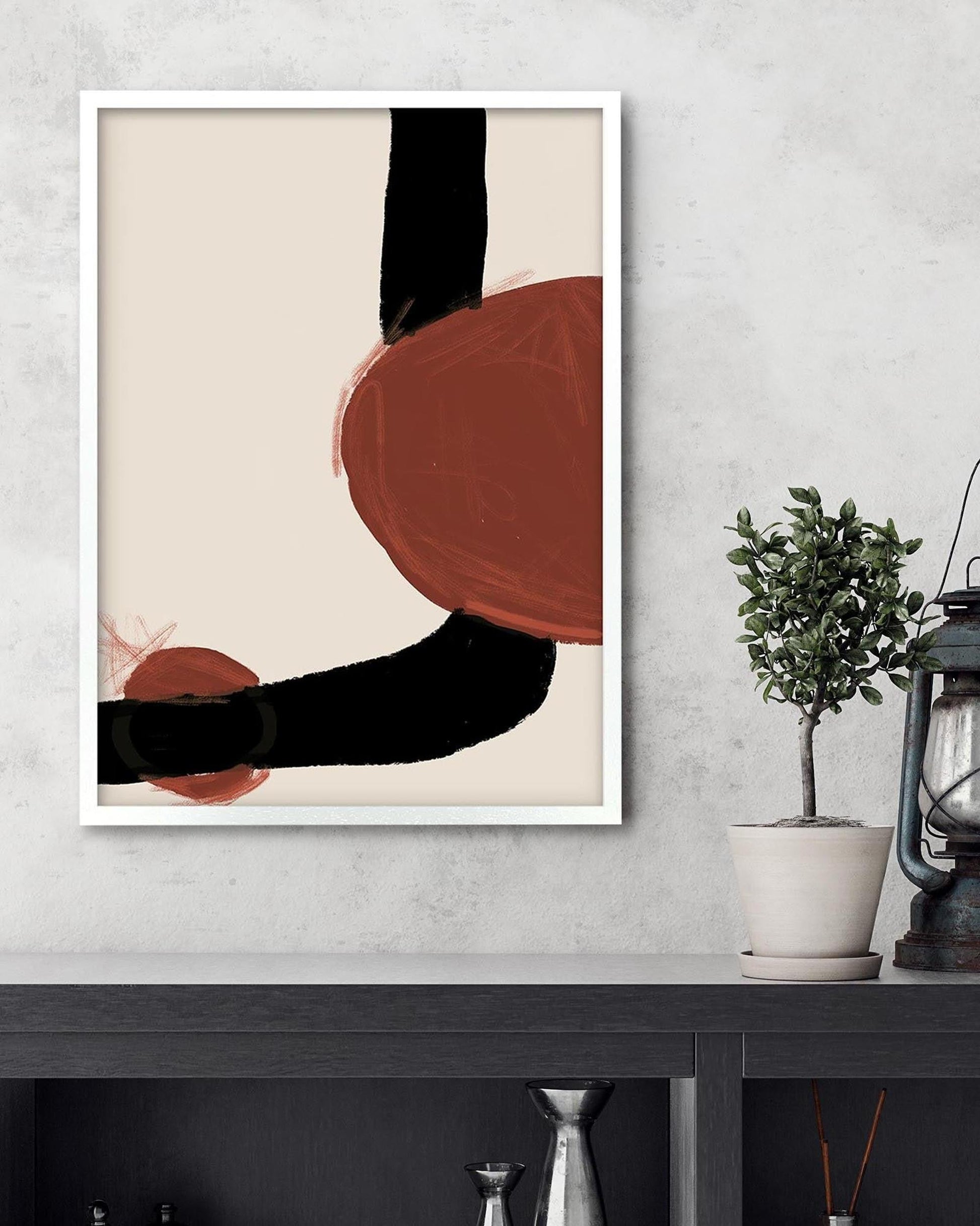 Abstract art print with red and black shapes on a beige background, framed and hanging on a wall.