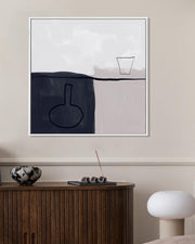 Abstract art piece on a wall above a wooden cabinet with decorative items.