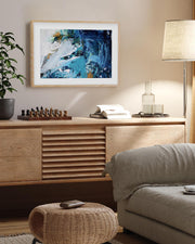 Living room with wooden sideboard, abstract painting, and decor items.