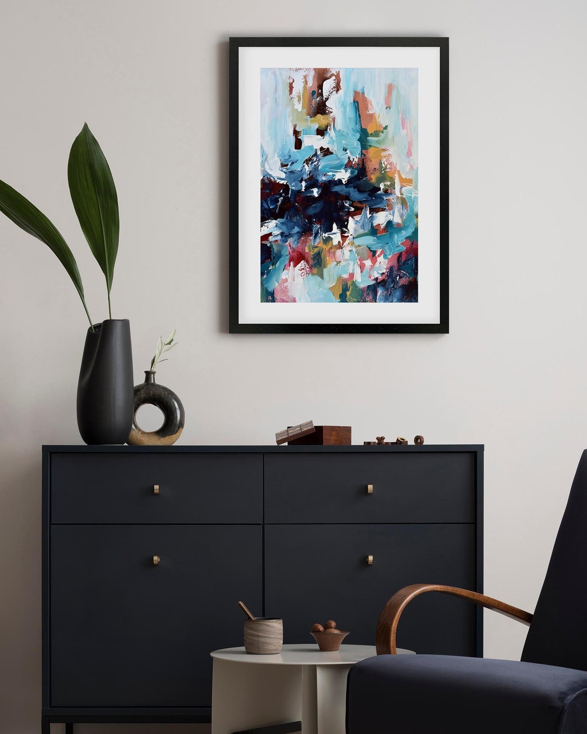 Modern interior with a black dresser, abstract art, and decorative items.