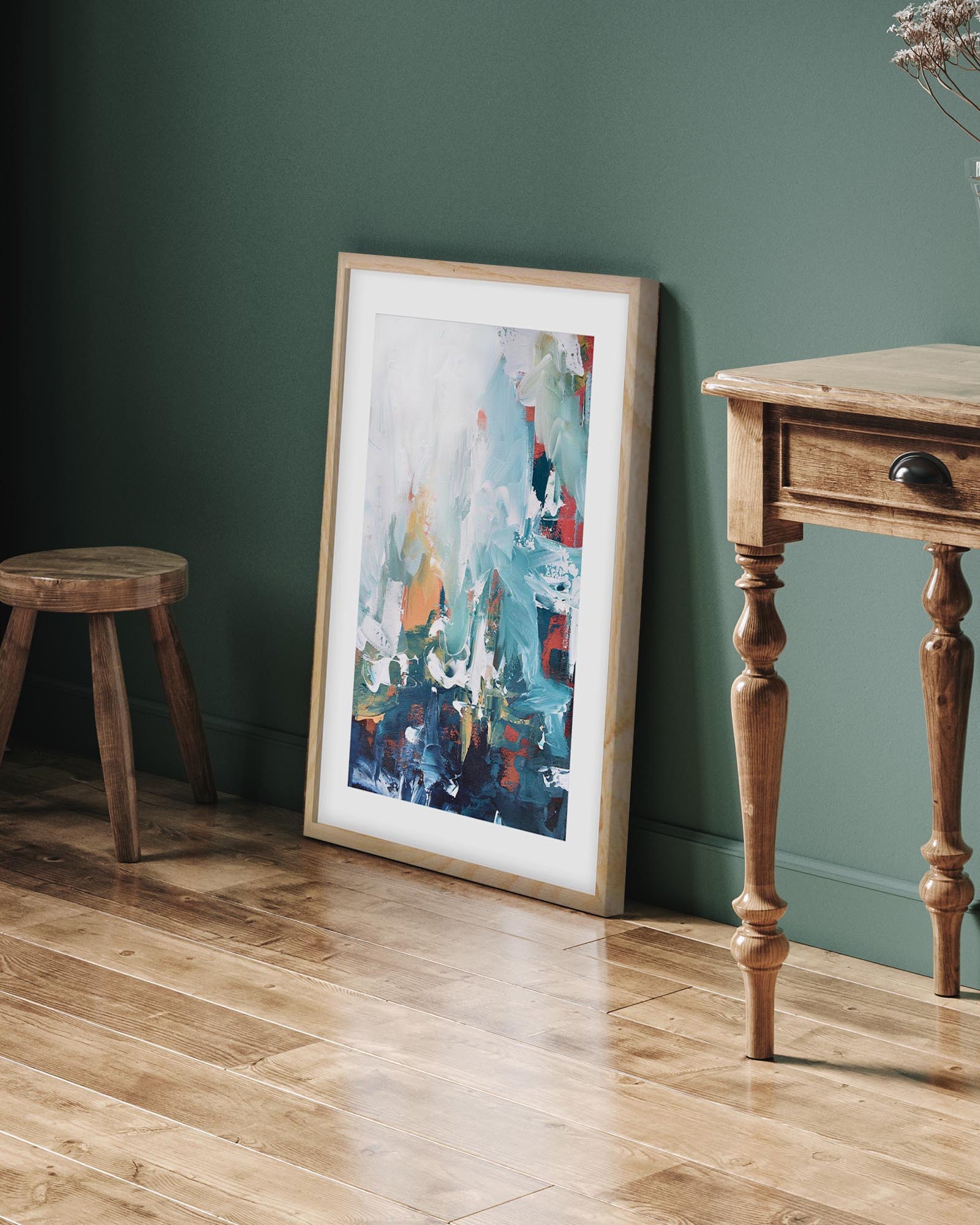 framed abstract artwork on a green wall
