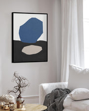 Abstract art print on a wall in a living room with a white sofa and decorative items.