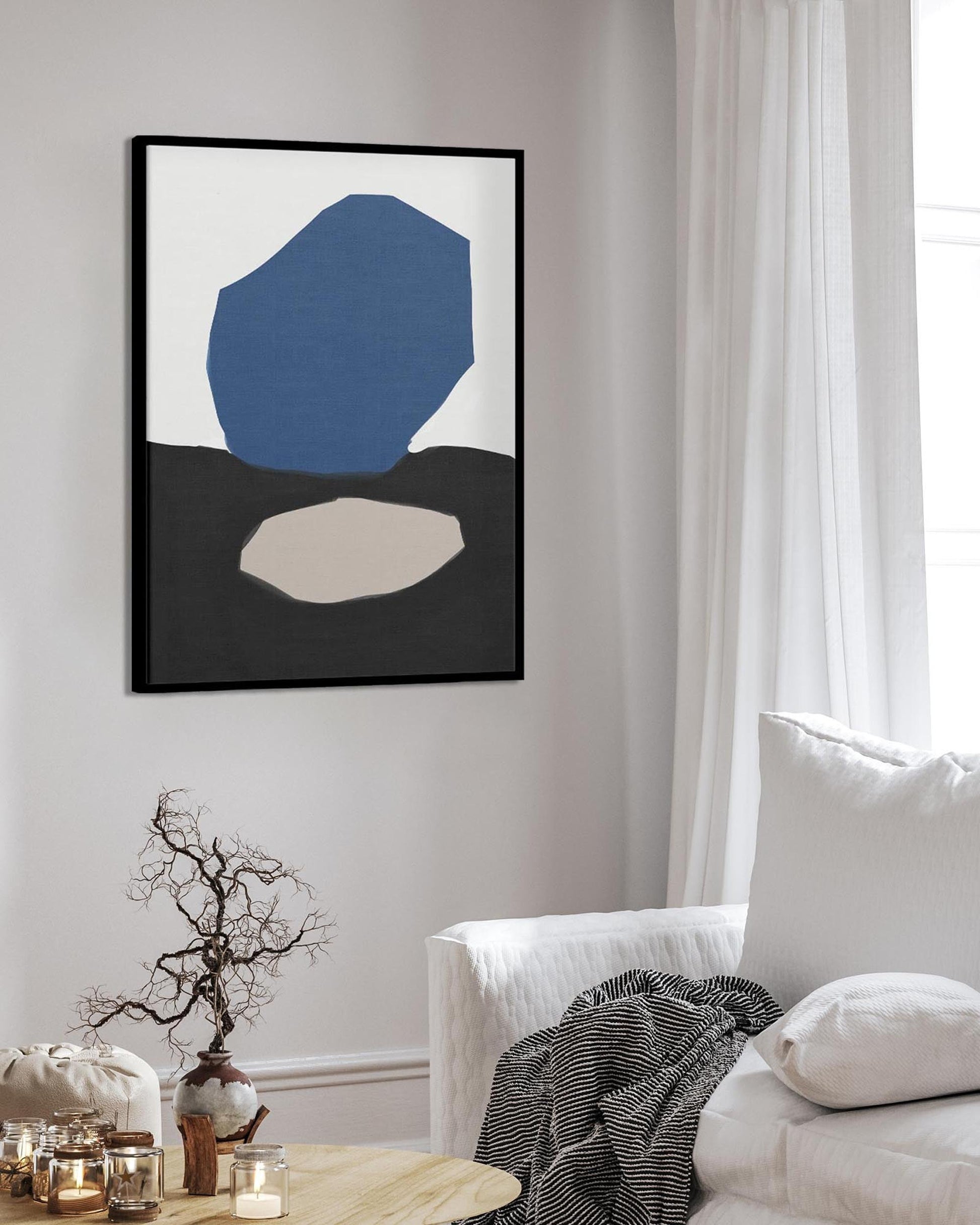 Abstract art print on a wall in a living room with a white sofa and decorative items.