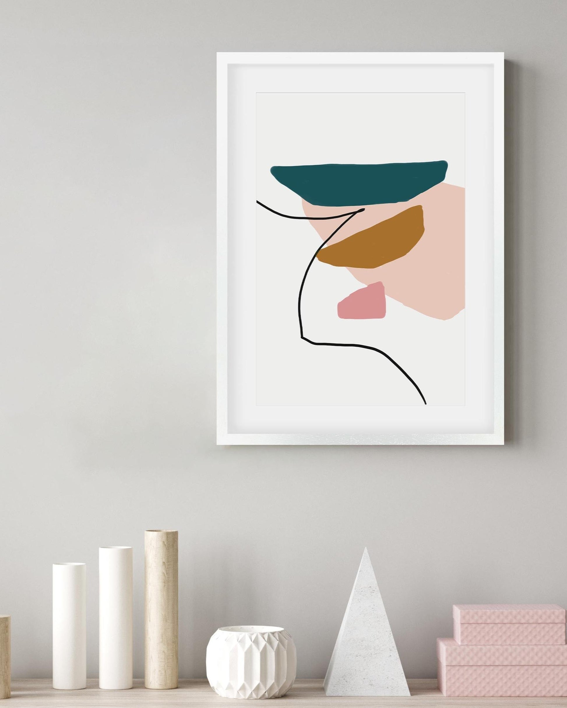 Framed abstract art print on a wall with decorative items below