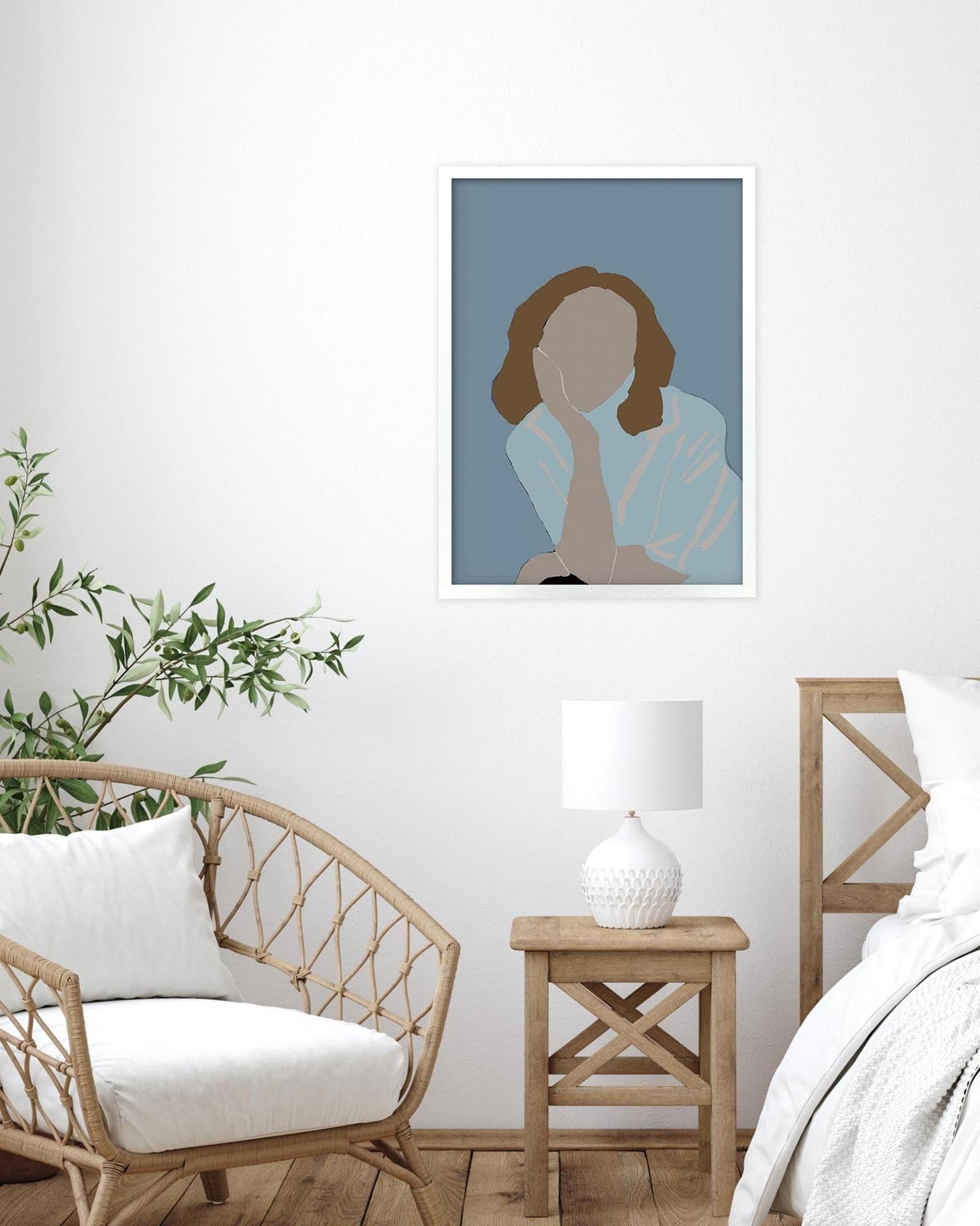 Living room with a wicker chair, side table, and abstract art on the wall.