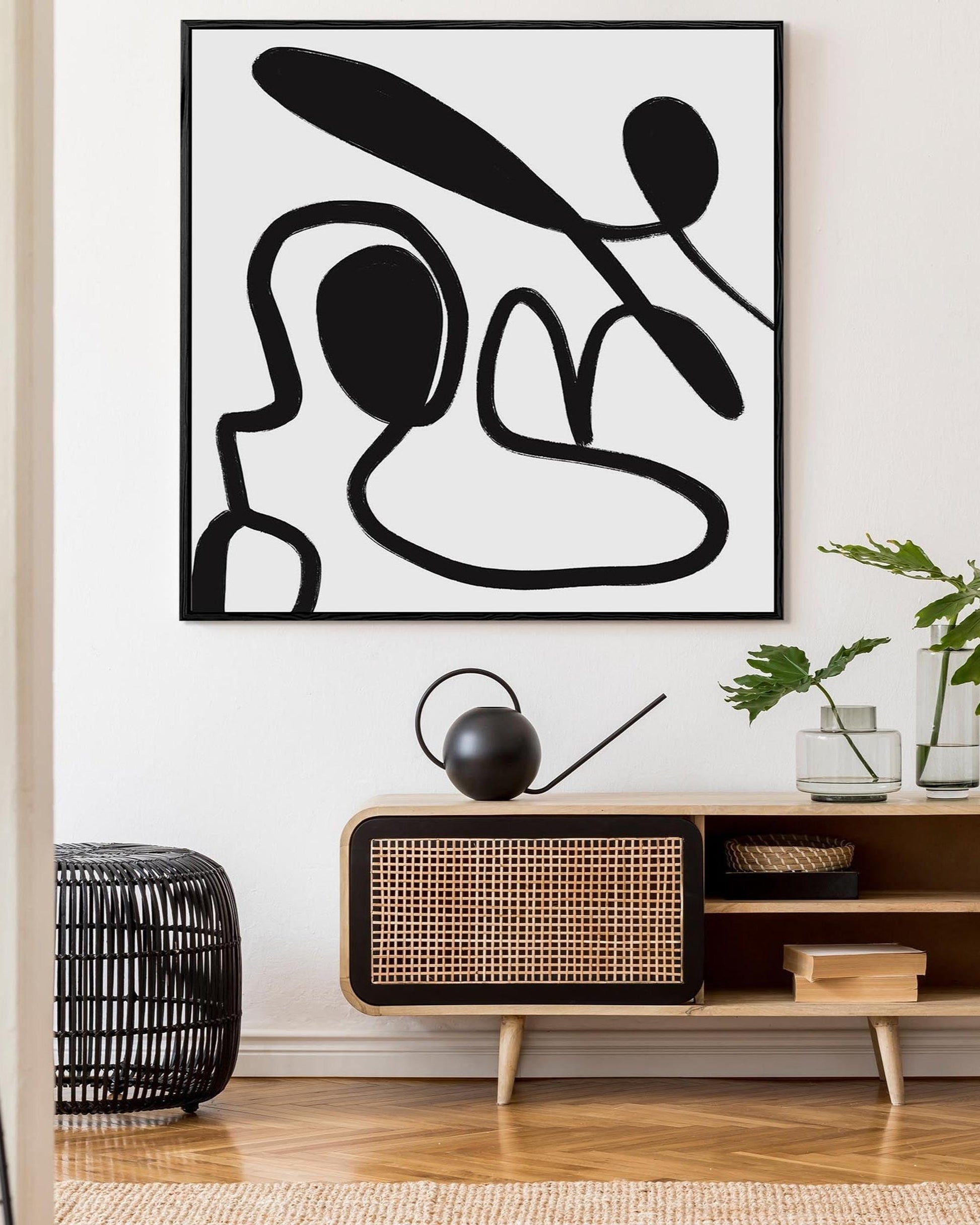 Abstract black and white artwork on a wall in a modern living room.