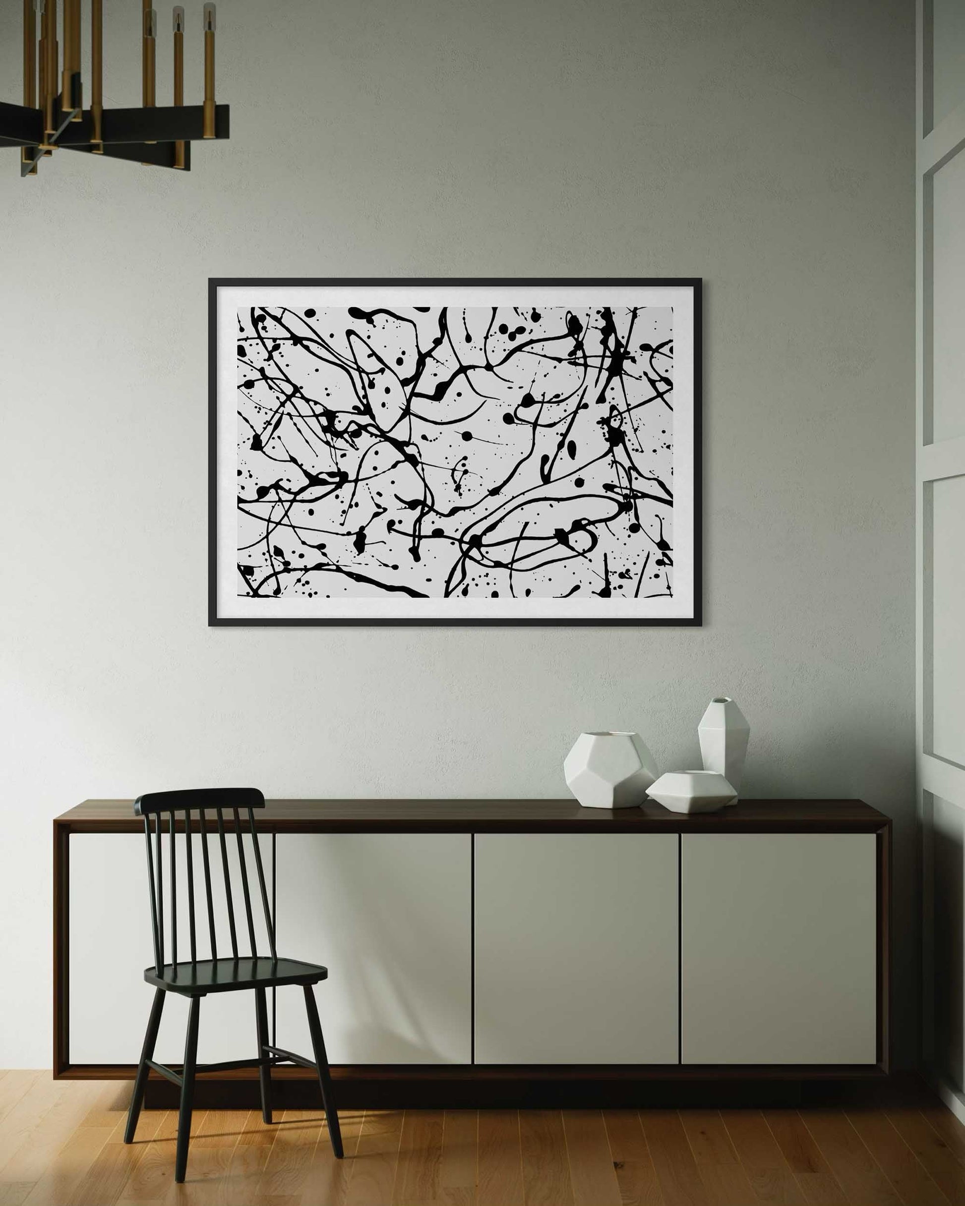 Abstract black and white painting on a wall above a console table with decorative items.