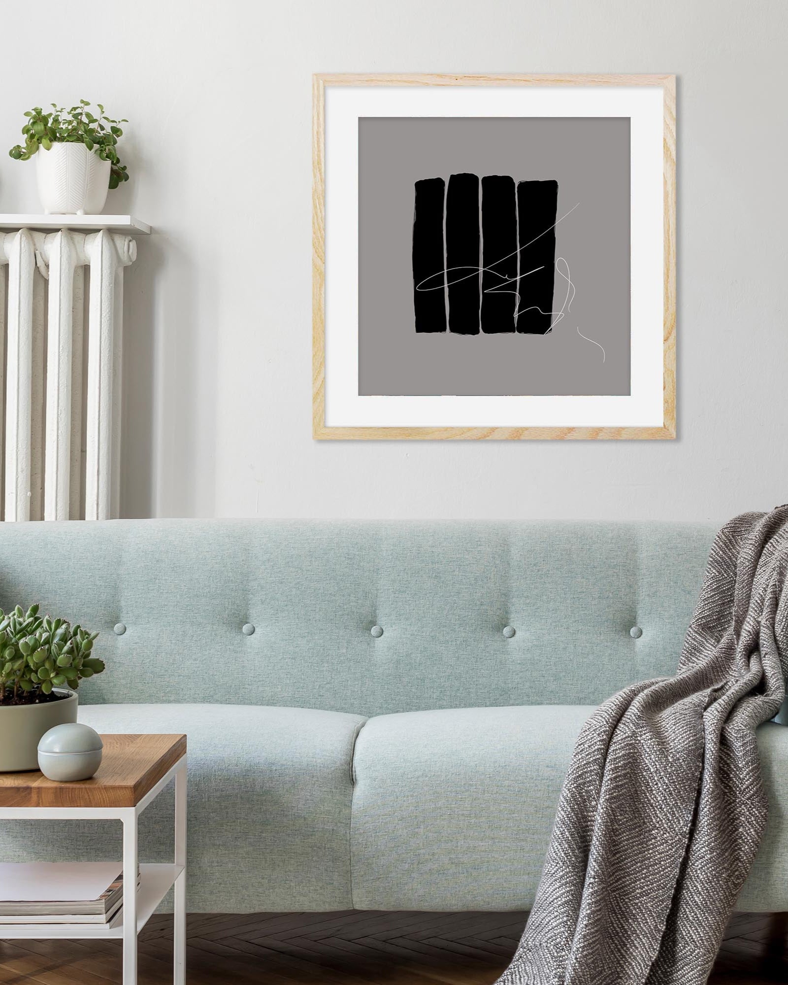Framed abstract art piece on a wall above a light blue sofa in a living room.