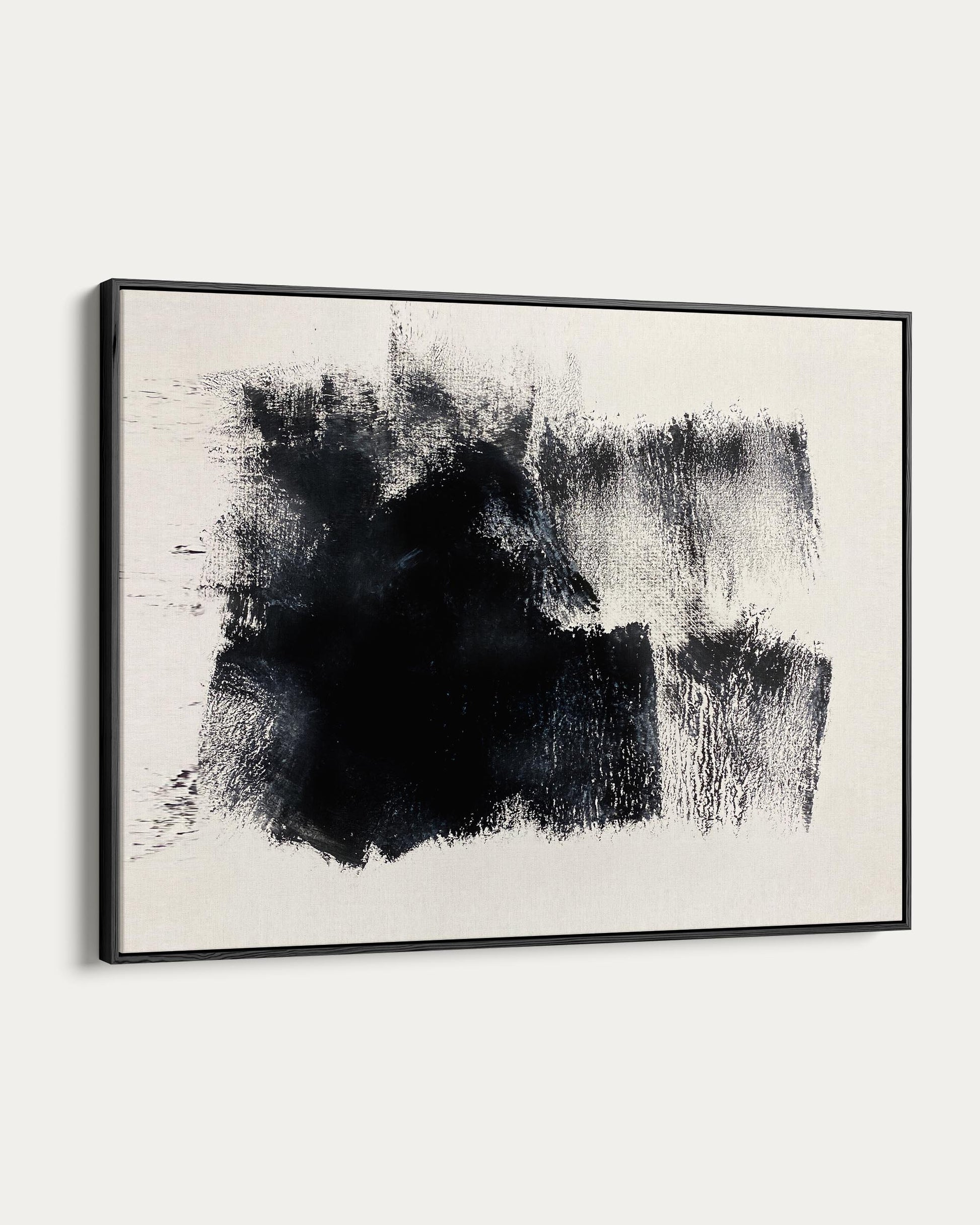 Abstract black and white painting in a black frame on a white wall