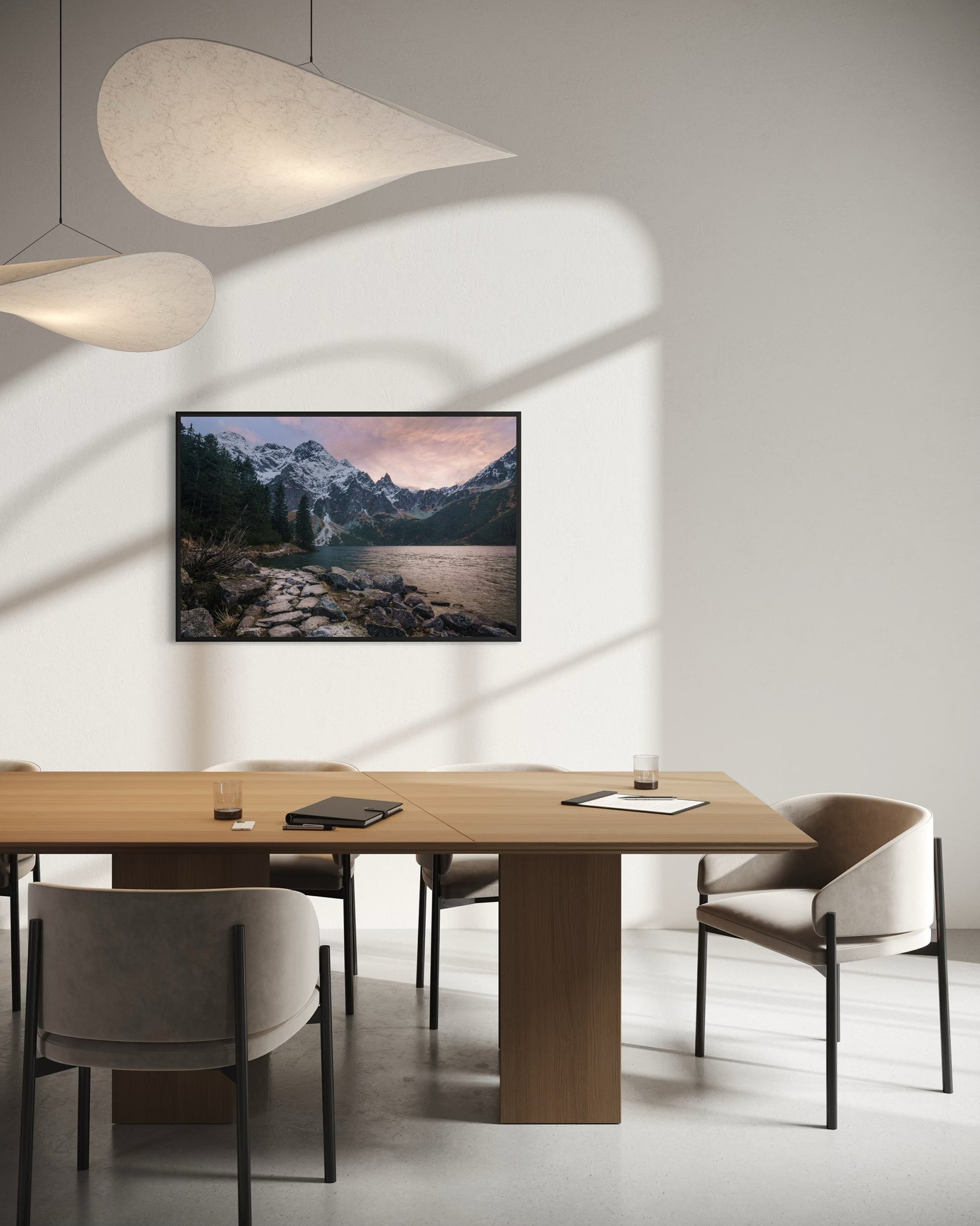 Modern dining room with a wooden table, chairs, and a mounted TV displaying a mountain landscape.