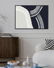 Modern living room with abstract art, white armchair, and wooden cabinet.