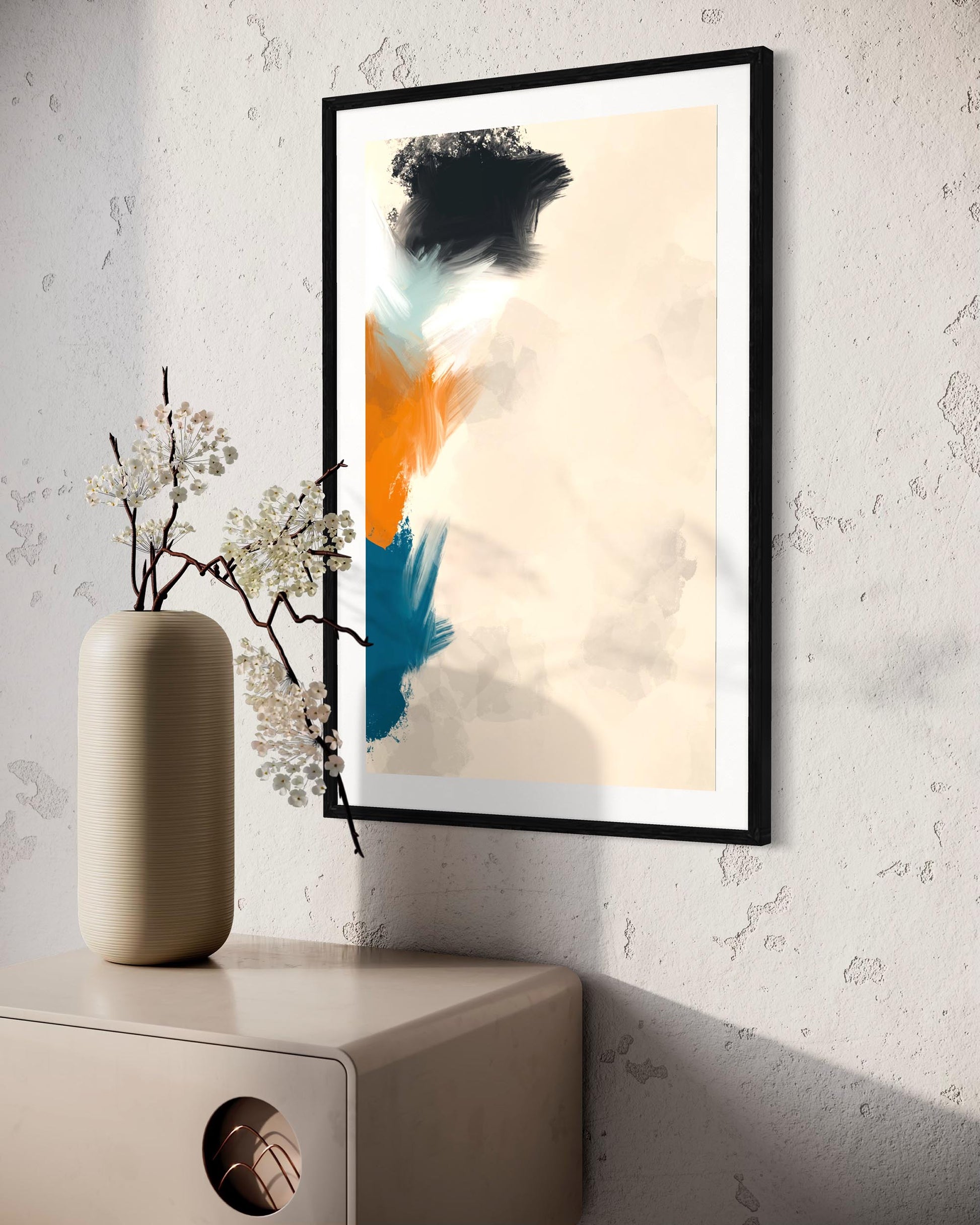 Framed abstract art piece on a wall with a vase and decorative branches below.
