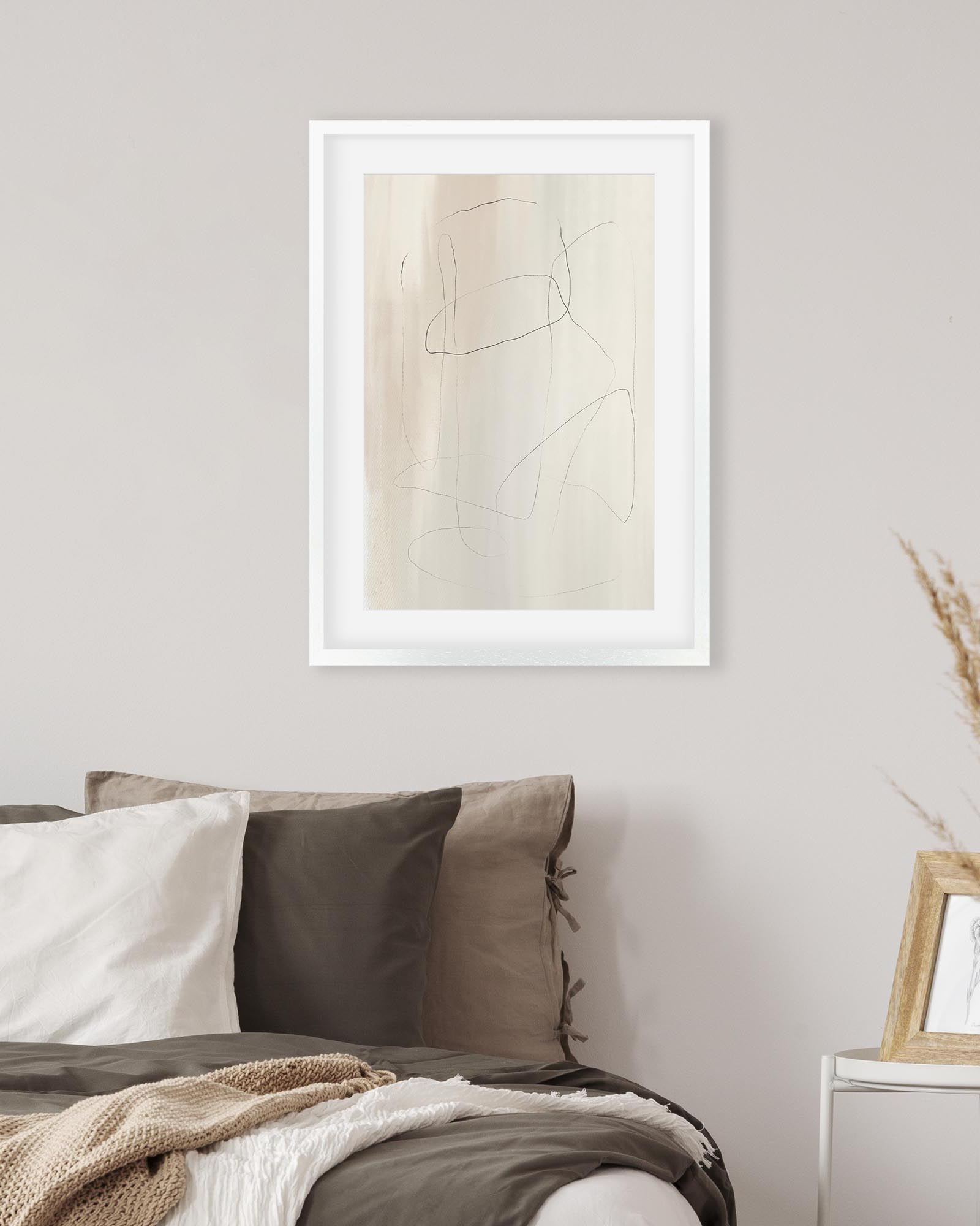 Framed abstract art piece on a wall above a sofa with neutral tones.