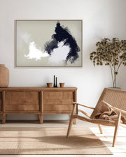 Living room with wooden sideboard, wicker chair, and abstract art on the wall.