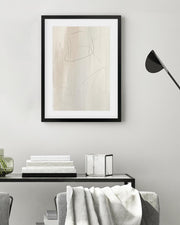 Framed abstract art on a wall above a console table with decorative items.