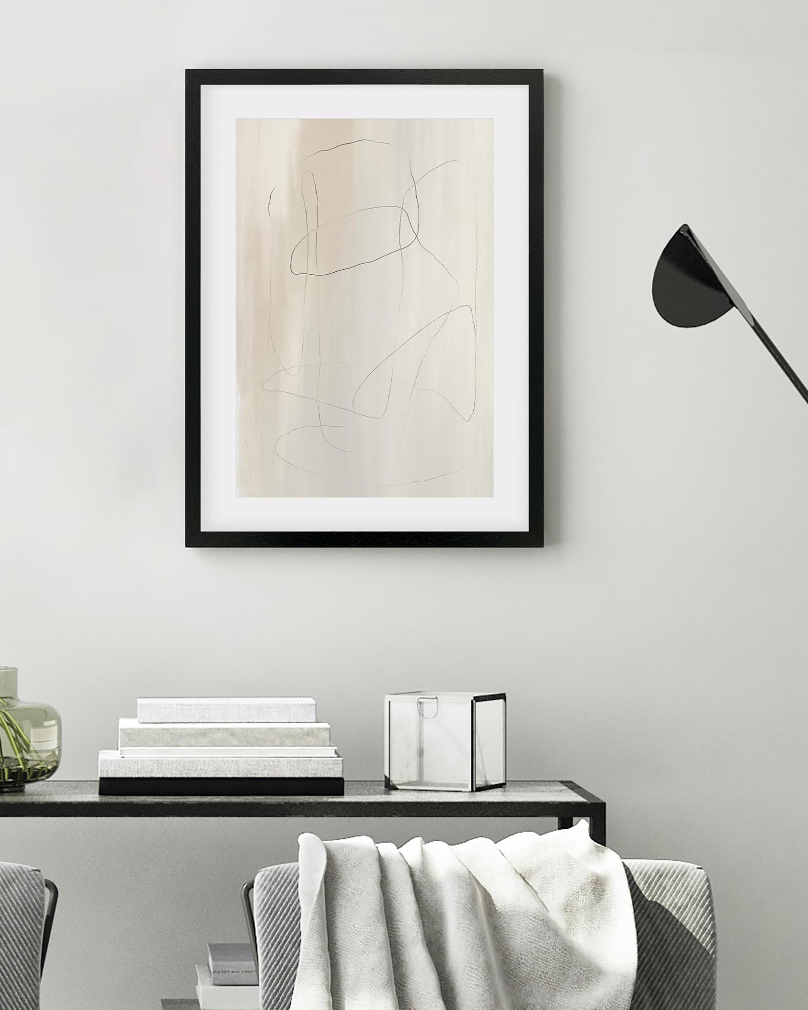 Framed abstract art on a wall above a console table with decorative items.