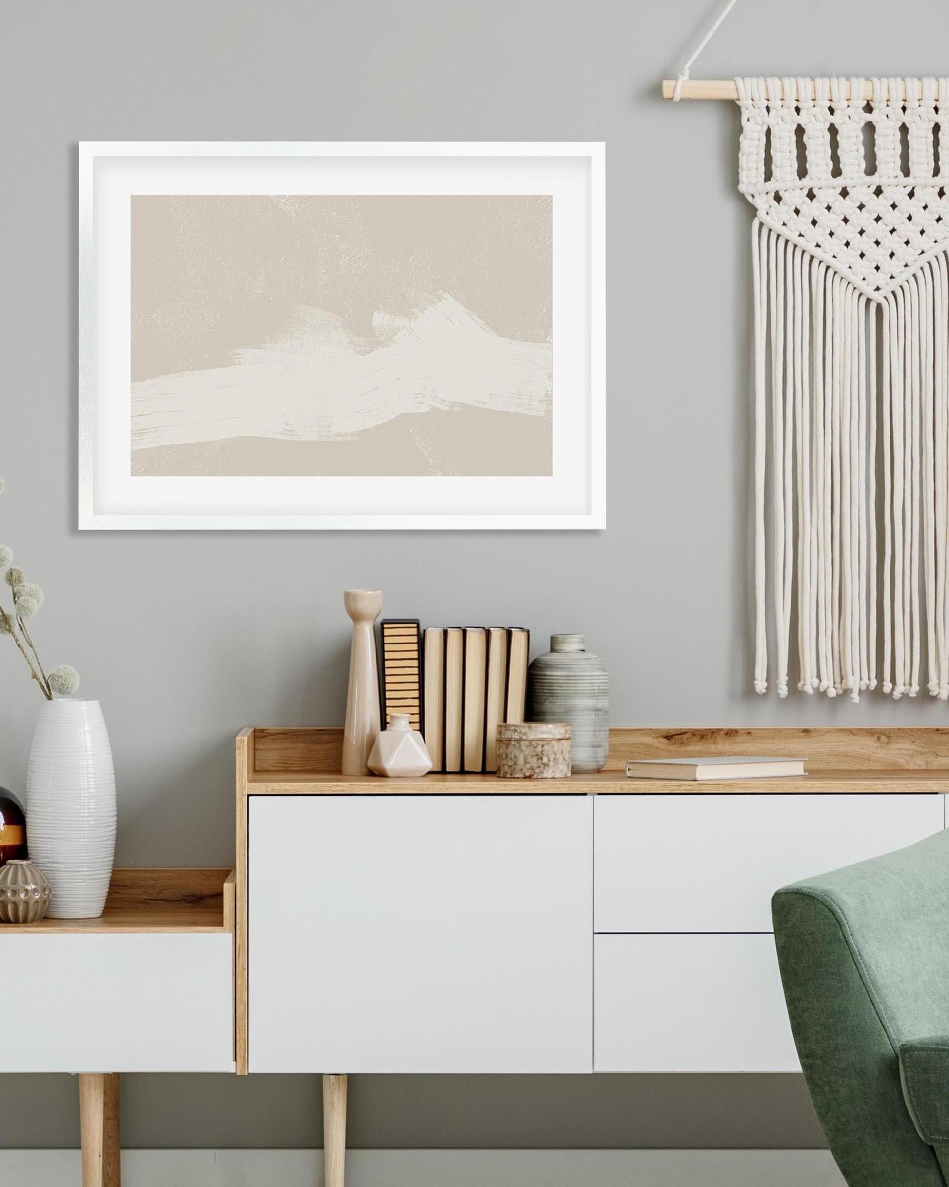 Modern interior with a sideboard, framed artwork, and decorative items against a gray wall.