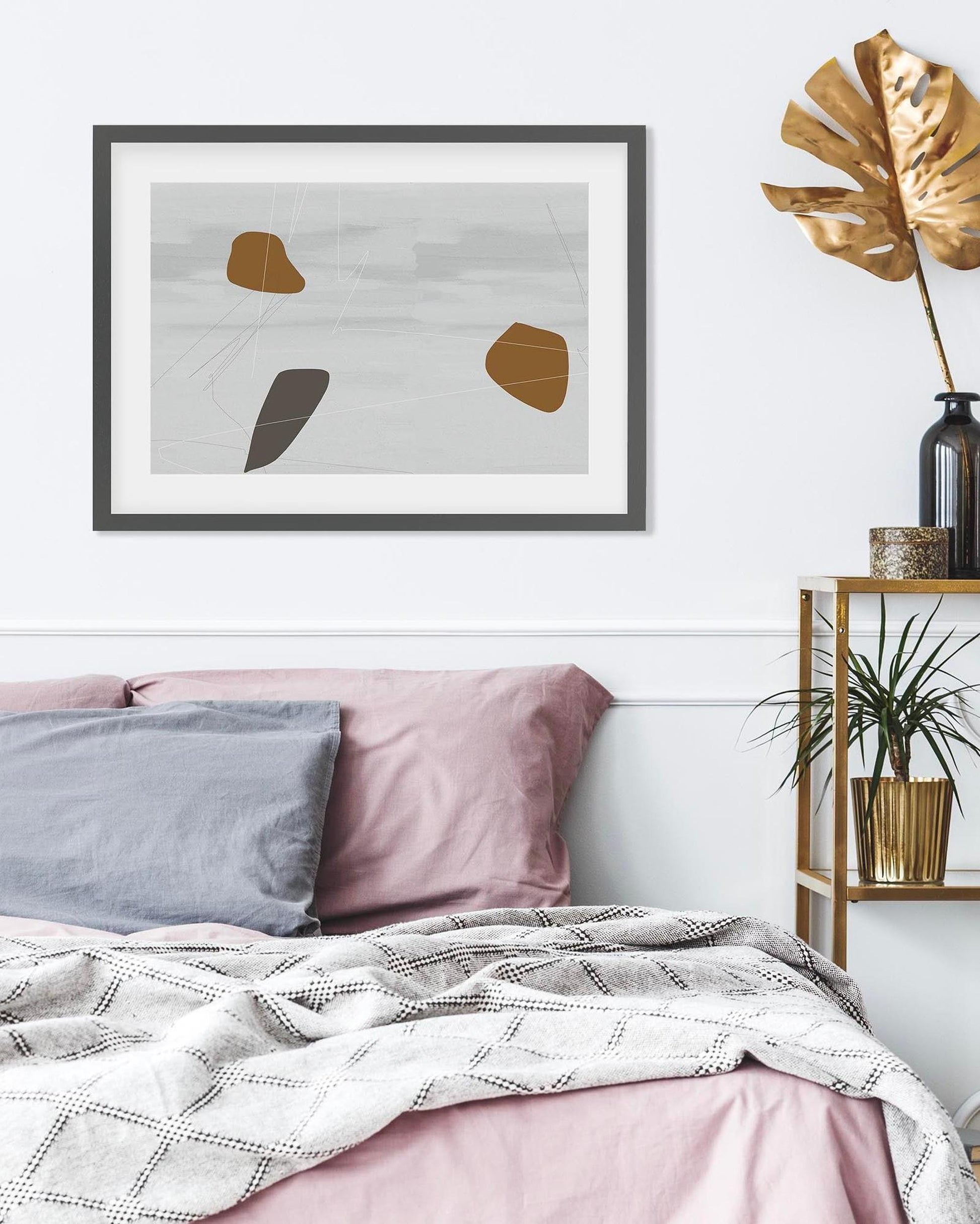 Bedroom with abstract art on the wall, pink bedding, and a shelf with plants.