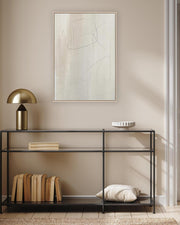 Modern interior with a black console table, gold lamp, and abstract painting on a beige wall.