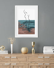 Framed abstract artwork on a gray wall above a wooden console table with decorative items.