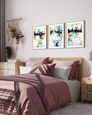 Bedroom with a bed featuring pink and brown bedding, three abstract art pieces on the wall, and a side table.