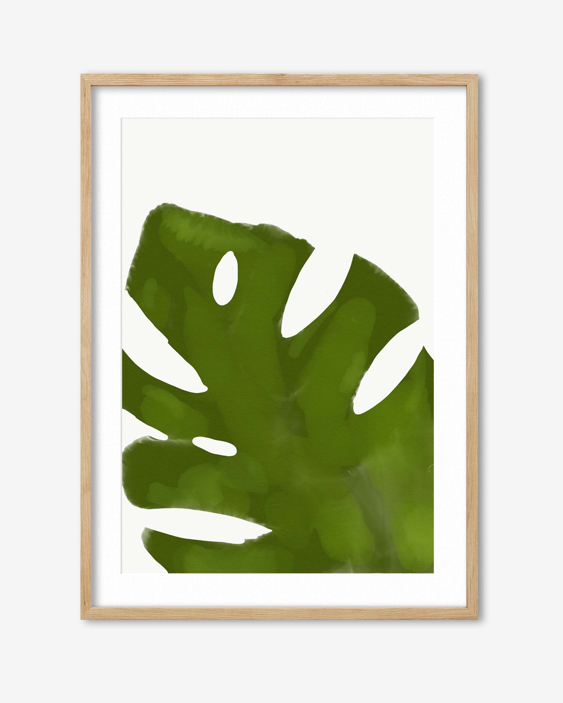 Framed artwork of a green leaf with a wooden frame on a white background