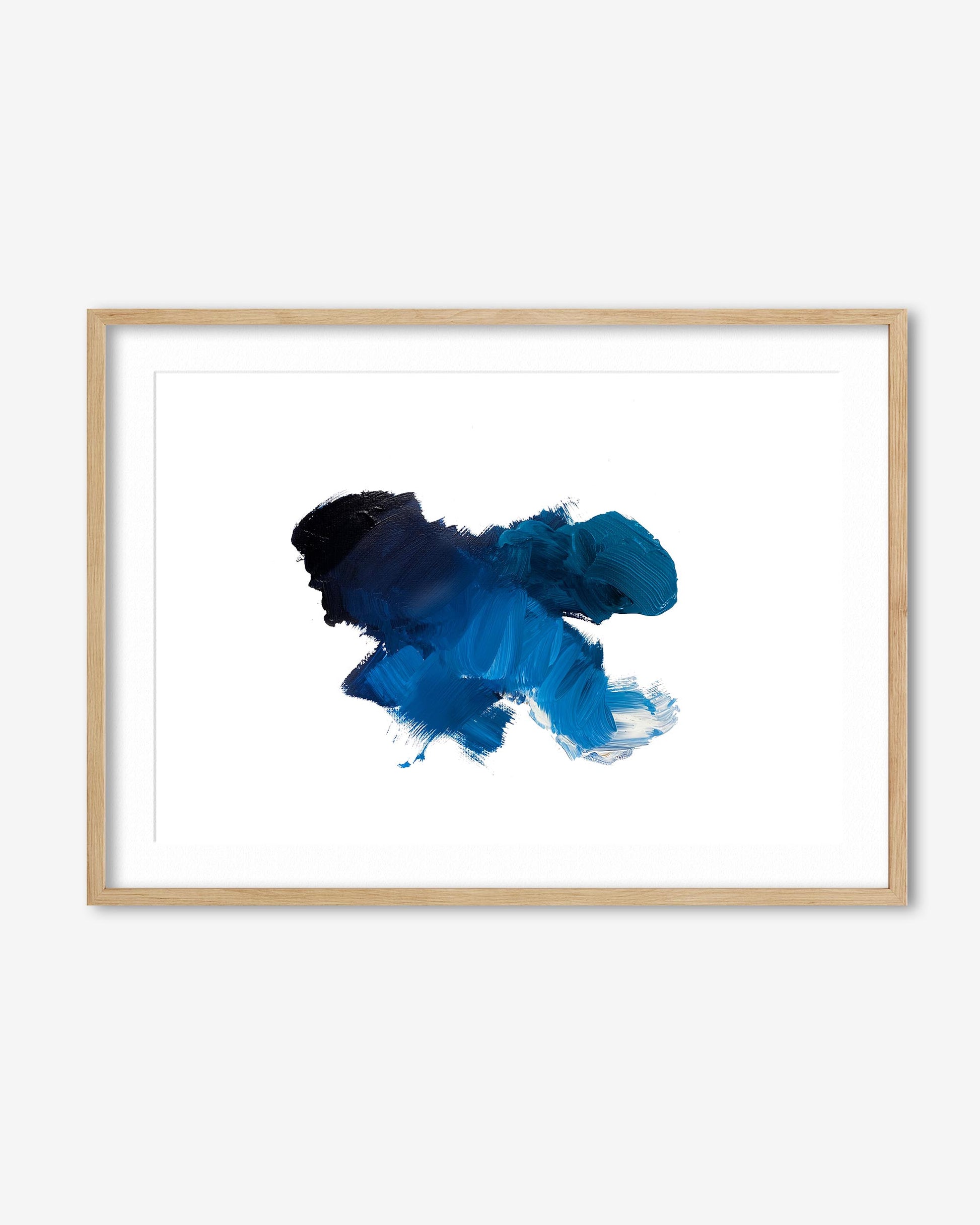 Framed abstract art piece with blue and black ink splashes on a white background