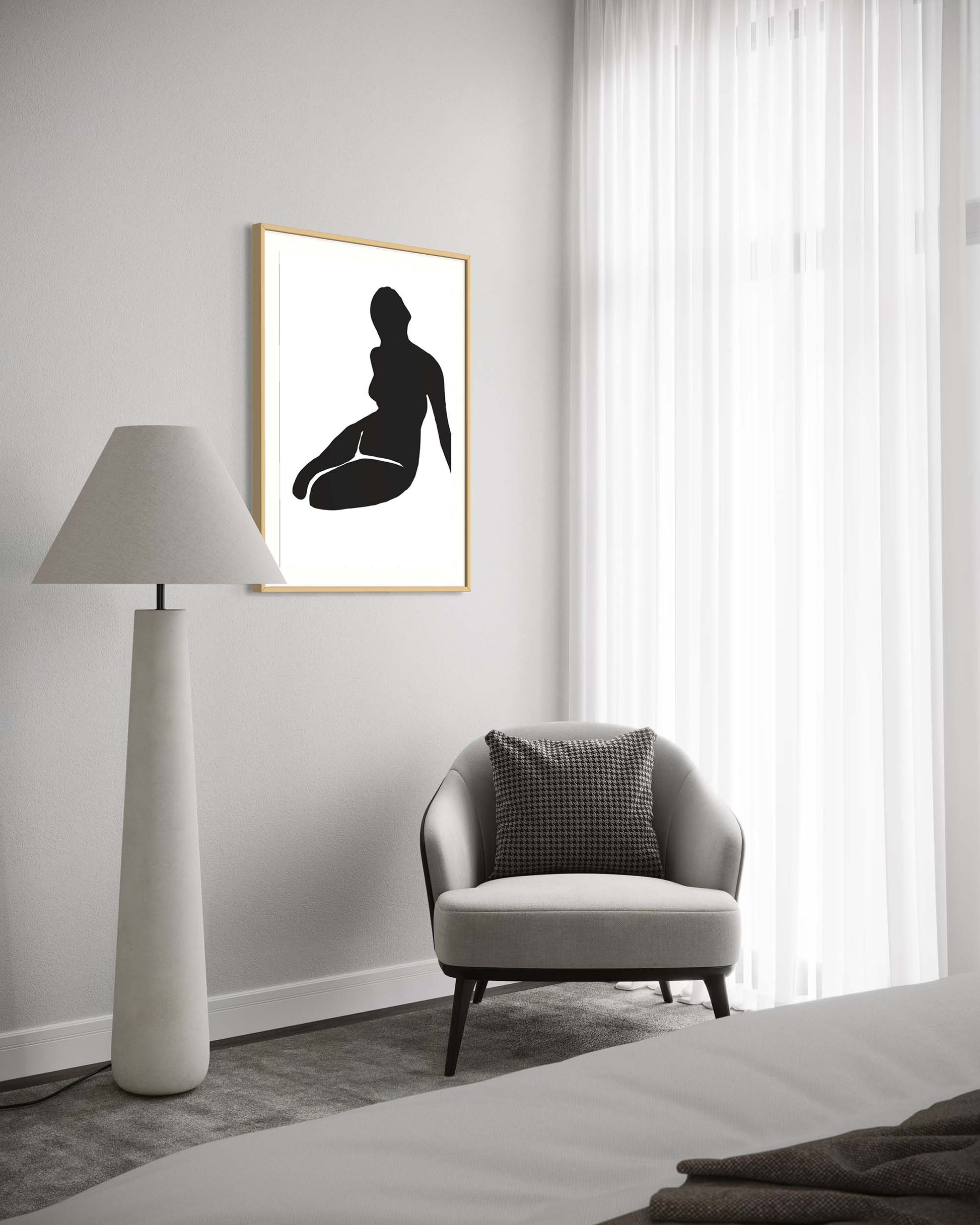 Modern interior with a framed black silhouette art print on a white wall, a gray armchair, and a floor lamp.