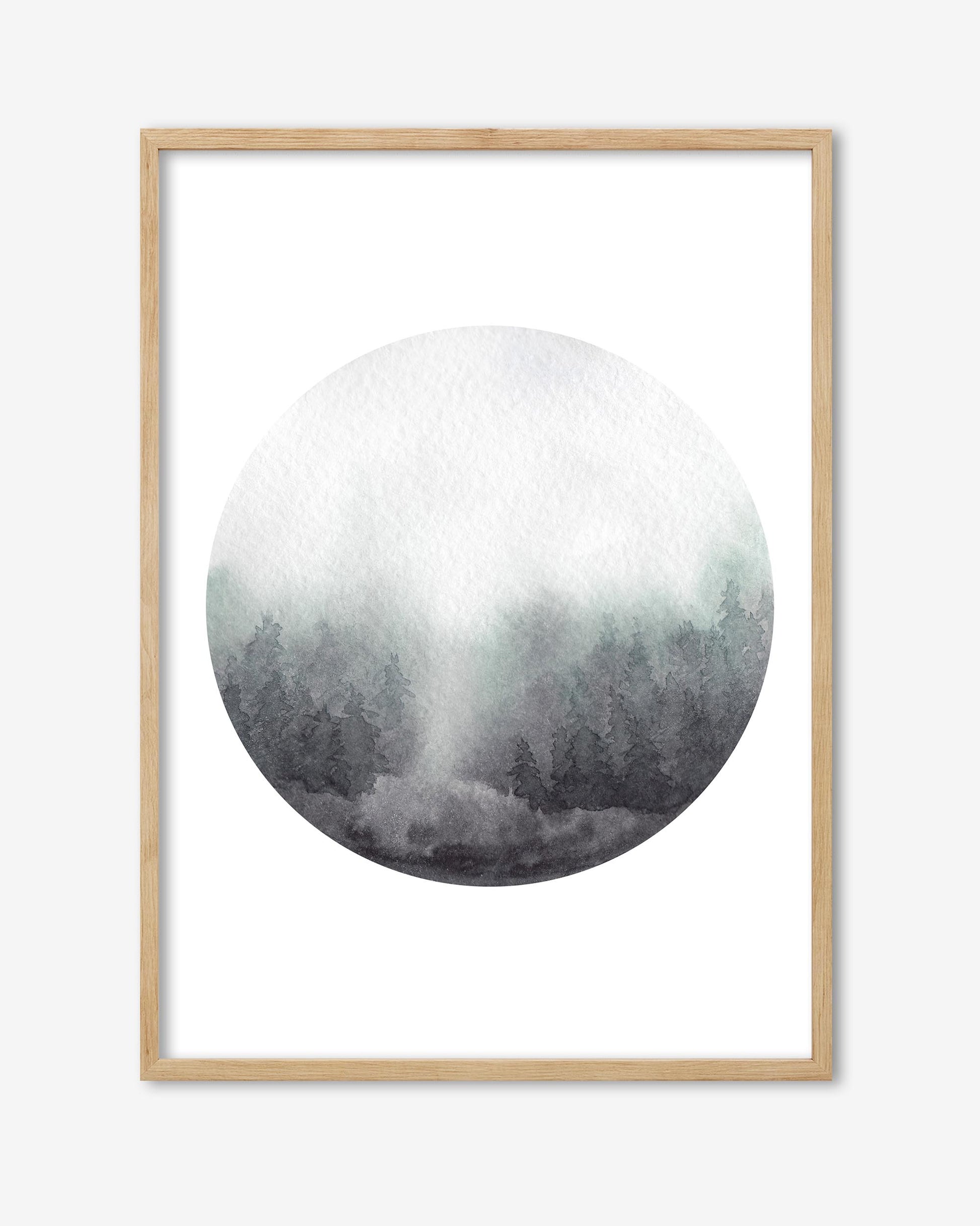 Framed circular artwork of a forest with a light wood frame on a white background