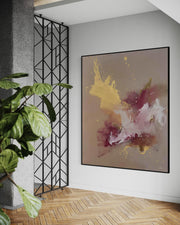 Abstract painting on a wall with a plant and geometric wall art in the foreground.